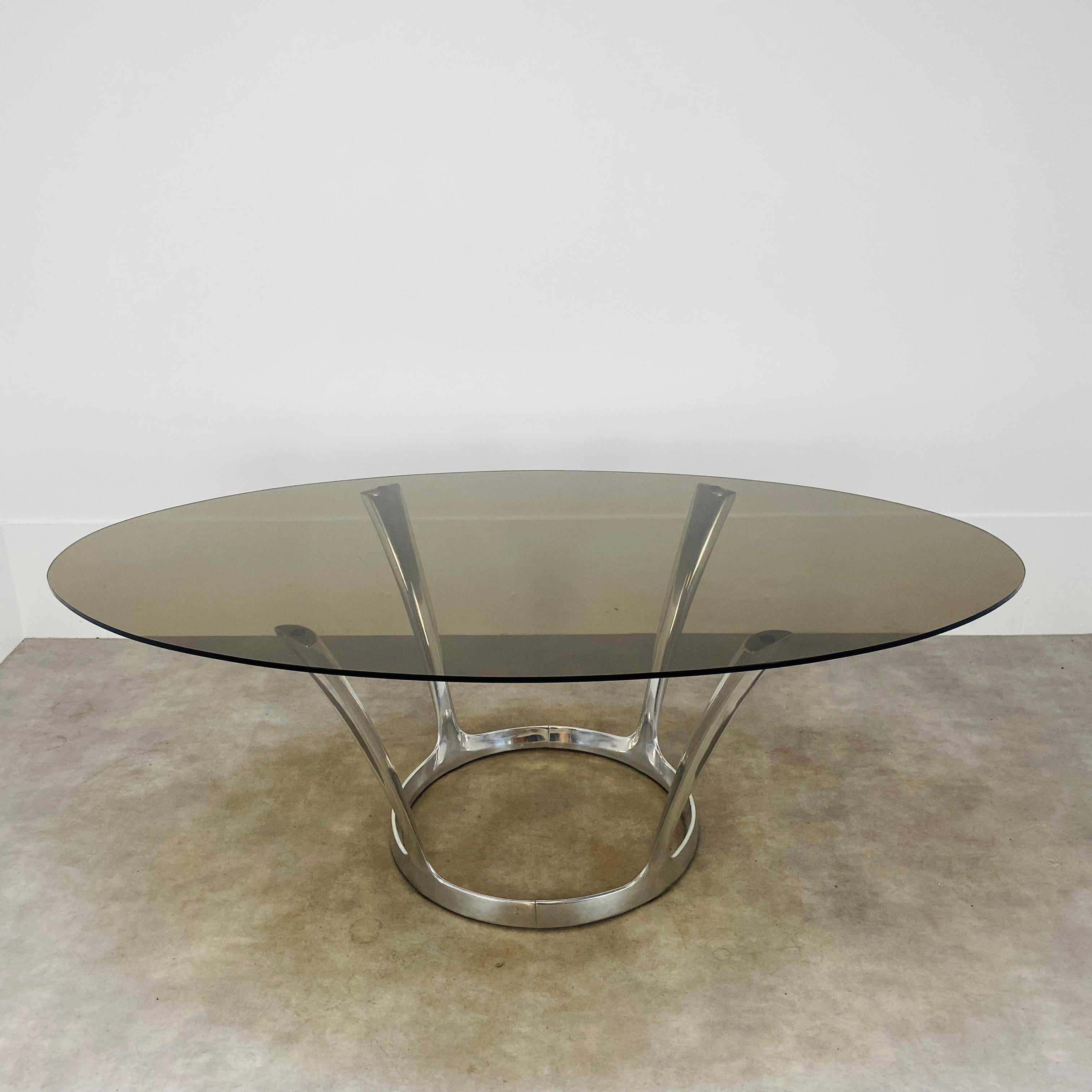 Ovaler Esszimmertisch des französischen Designers Michel Charron, typisches Design aus den siebziger Jahren. 
Sehr guter Zustand, seltene Gebrauchsspuren auf dem Glas und dem Aluminiumsockel. Keine Splitter auf dem Glas. Der Tischfuß ist zerlegbar. 