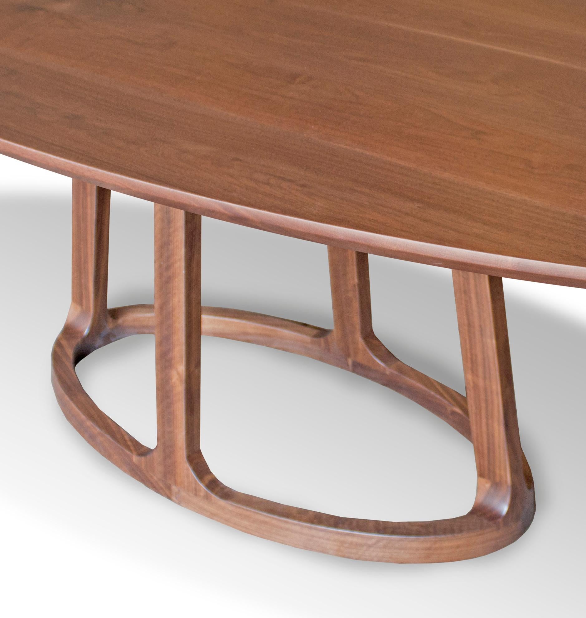 This inviting elyptical dining table is carved from solid American Black Walnut. Its unique pedestal base gives this table a simple handcrafted elegance that will bring authenticity to any space in which it calls home.