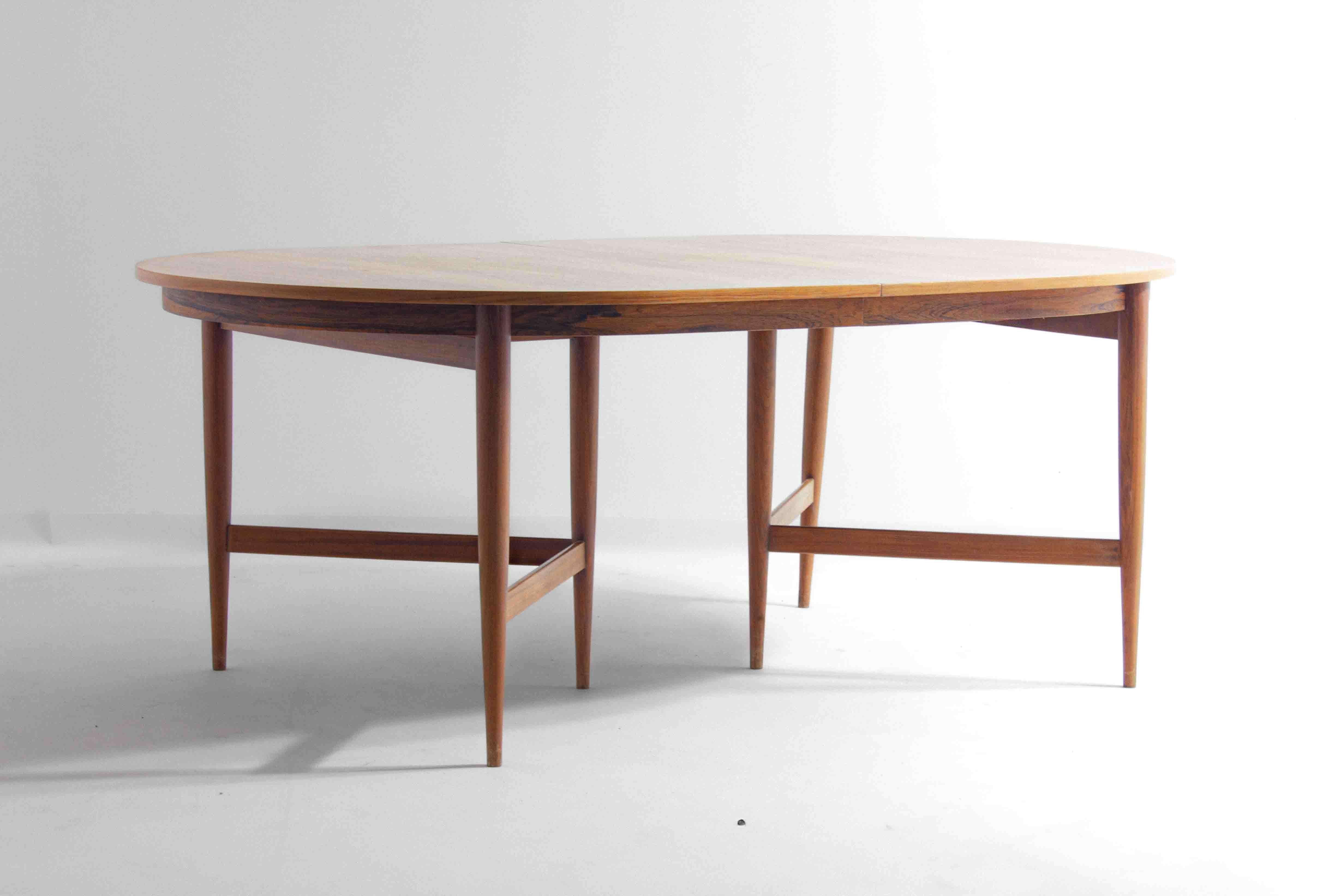 Ovaler Esstisch aus Teakholz, entworfen von Oswald Vermaercke für V-Form im Jahr 1962.
Der Tisch ruht auf konisch zulaufenden, runden Beinen, die durch Querstreben in einer dreieckigen Konstellation miteinander verbunden sind und für zusätzliche
