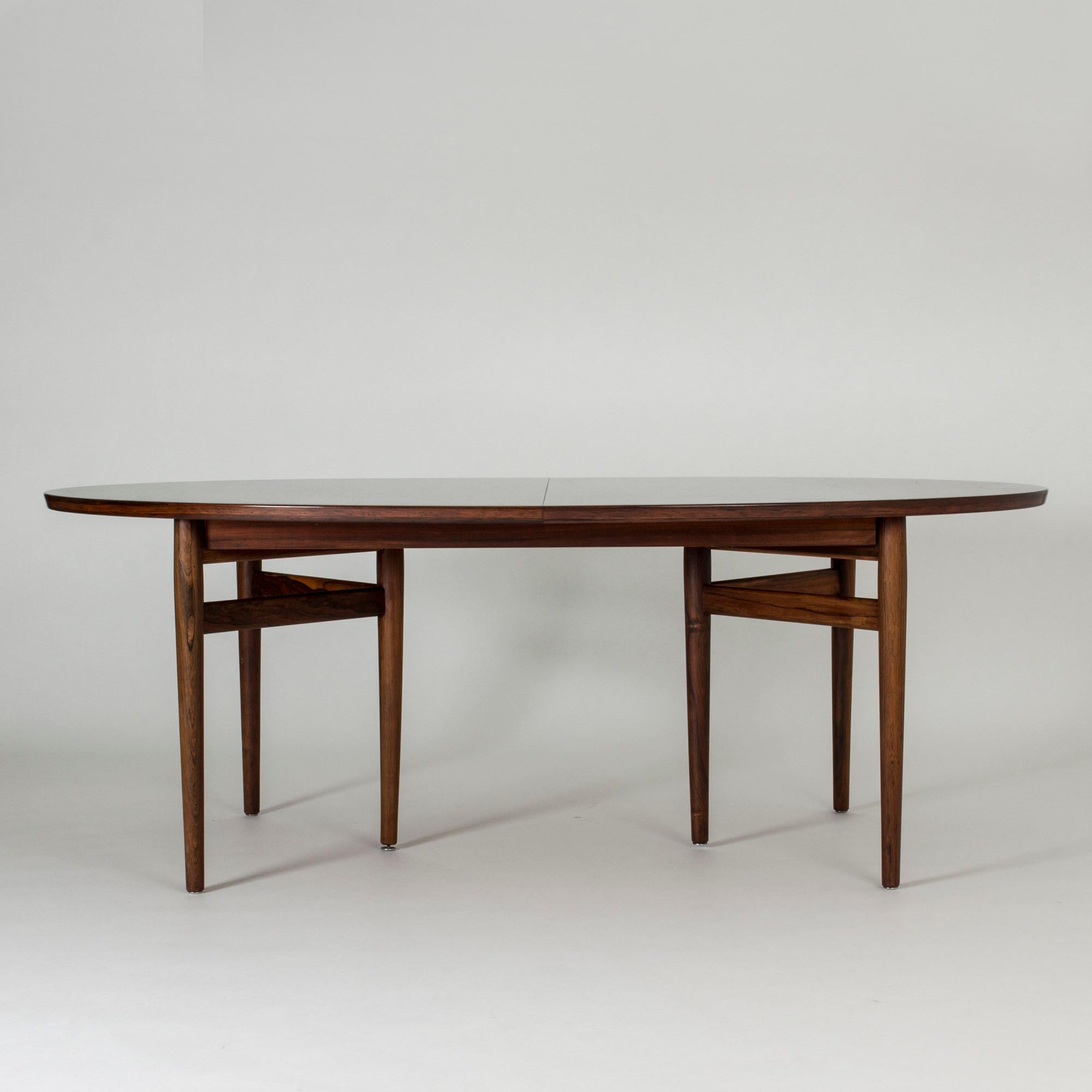 Large, oval dining table by Arne Vodder, made from rosewood. Six legs set in a triangular formation at each end. Two extension leaves that match the nuance of the table very well.

Measure: Width 197.5 + 49.5 + 49.5 cm.