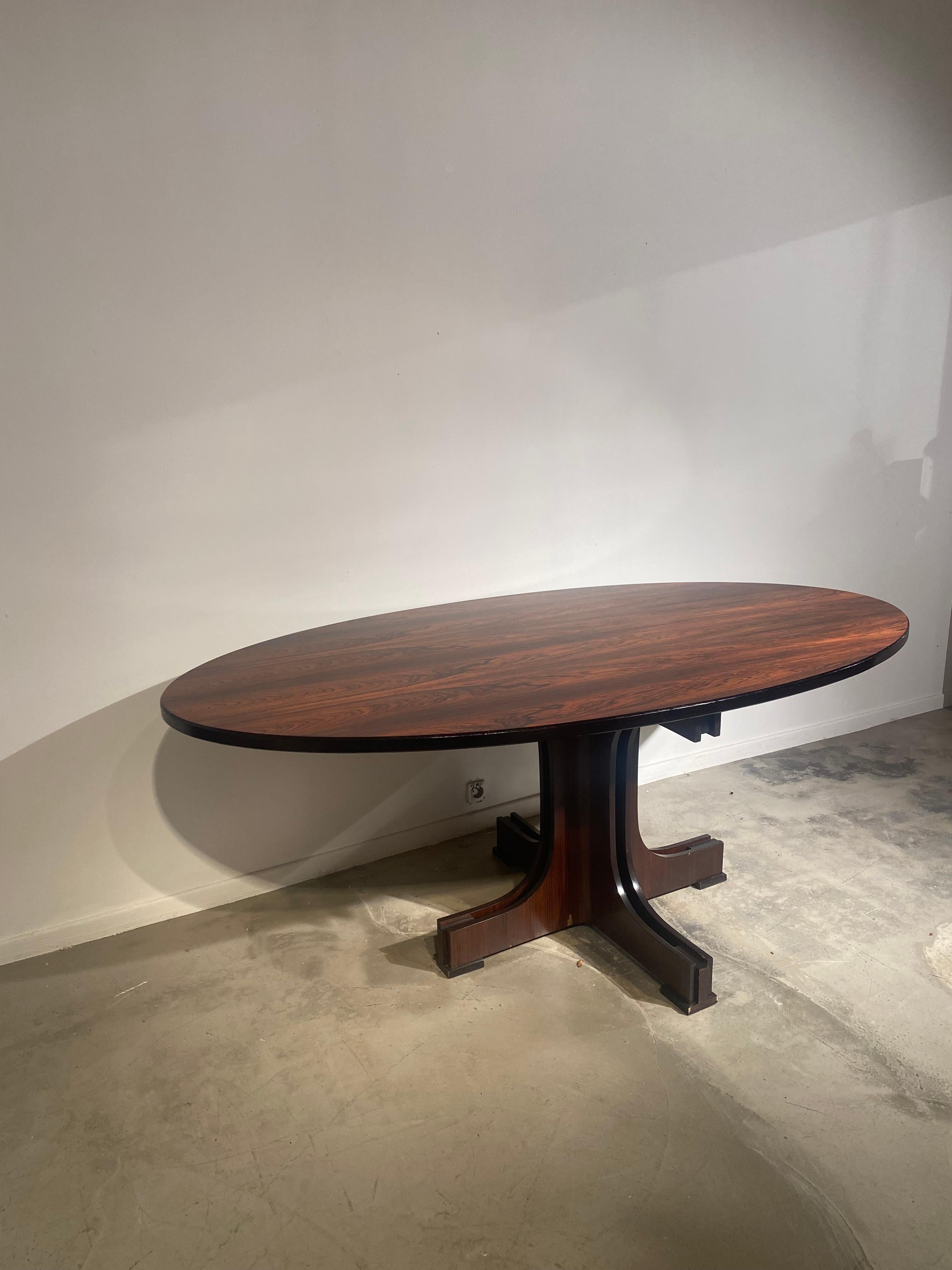 Beautiful Italian table with wood veneered top and sculptural basement. The wood top has a really nice patina and a black contouring offering an elegant finishing.