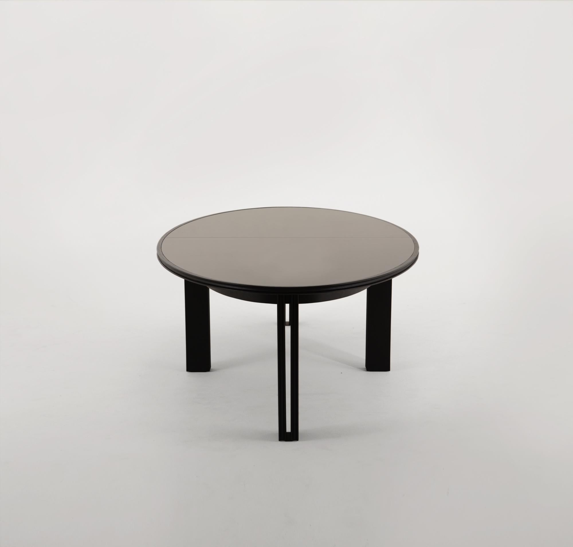 Vivien's table is crafted from a solid dyed oak tabletop, encasing two pieces of bronze glass that sit on eight hardwood oak legs. A concave profile carves the edges of the tabletop, and follows down the interior and exterior of the eight legs. The