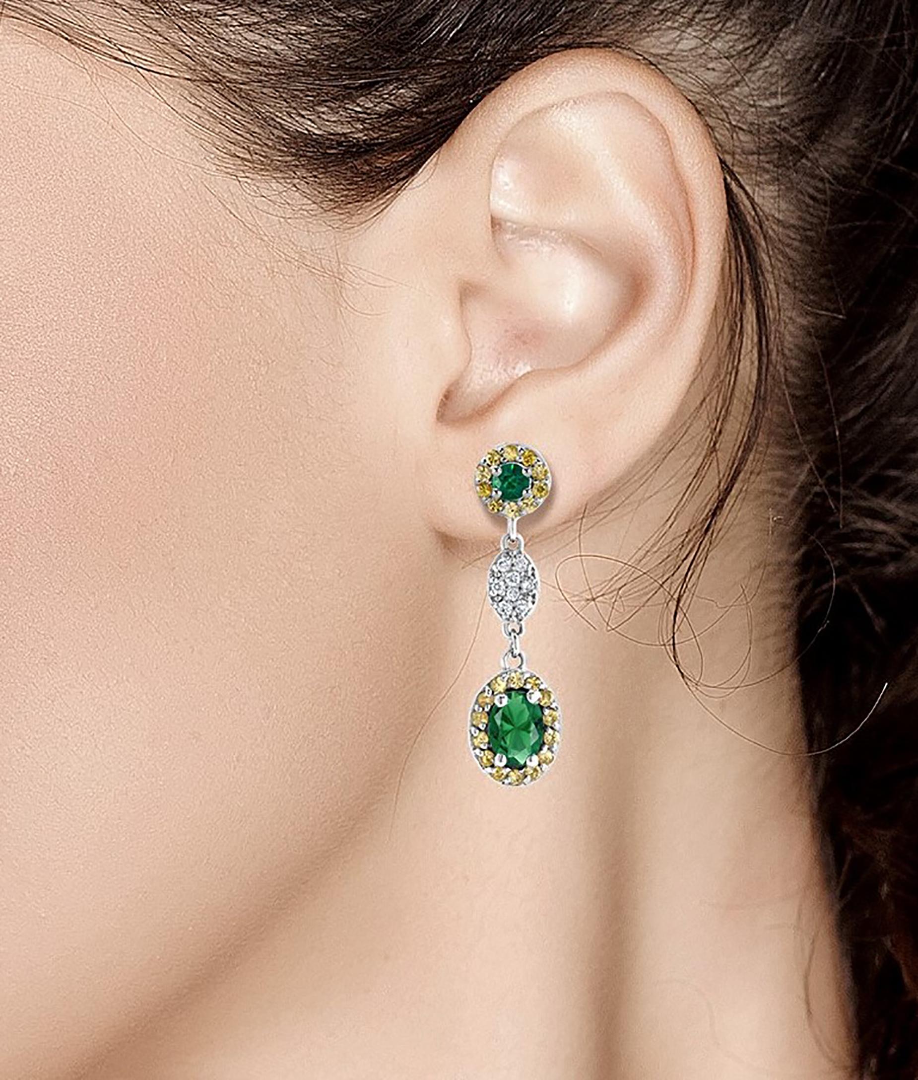 Fourteen karat white gold drop earrings with oval emerald, yellow sapphire and diamonds
Oval emerald weighing 1.10 carat 
Diamond weighing 0.20 carat 
Yellow Sapphire weighing 0.35 carat 
Earrings measuring one inch long 
One of a kind earrings 
New