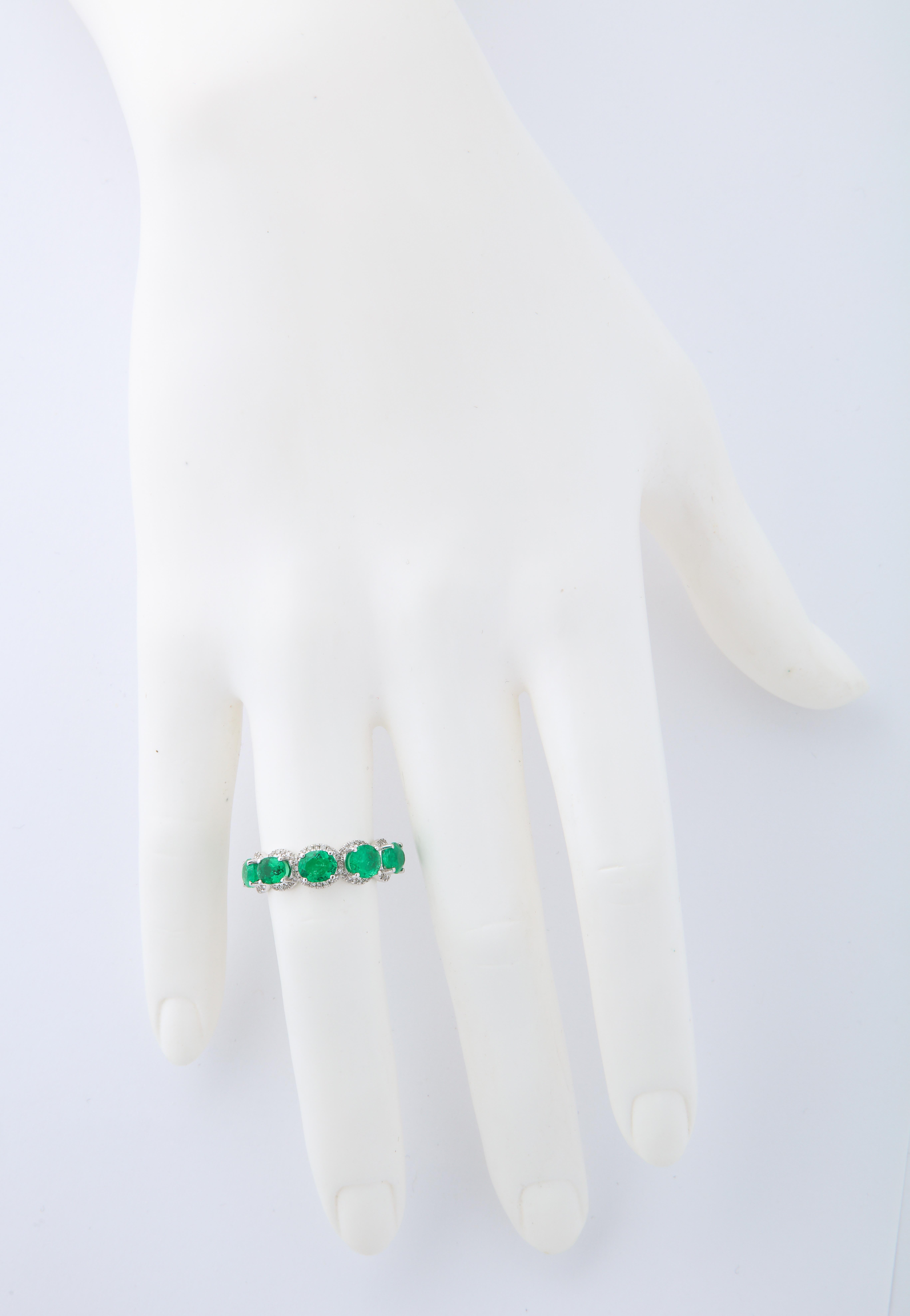 18kt white gold oval emerald (10=3.59cts) and diamond (0.44cts) eternity band.  This ring is destined to become a staple in anyone's jewelry collection and the micro pavé diamond halo setting around each emerald makes all the difference.  Just the