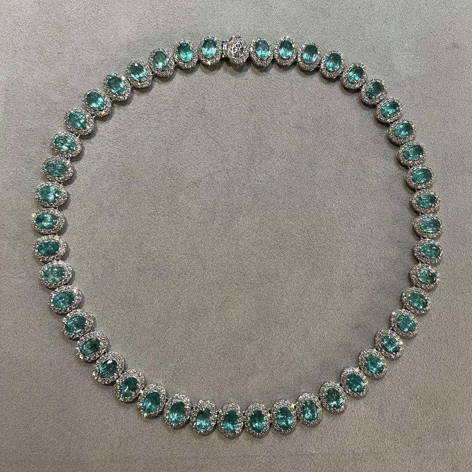 Oval Emerald and Diamond Choker Necklace Halo Setting in 18k White Gold

Emerald and Diamond Necklace feature 45 Natural Oval Green Emeralds weighing 29.52 carats in total surrounded by a halo of Natural Round Brilliant Diamonds, all set in 18k
