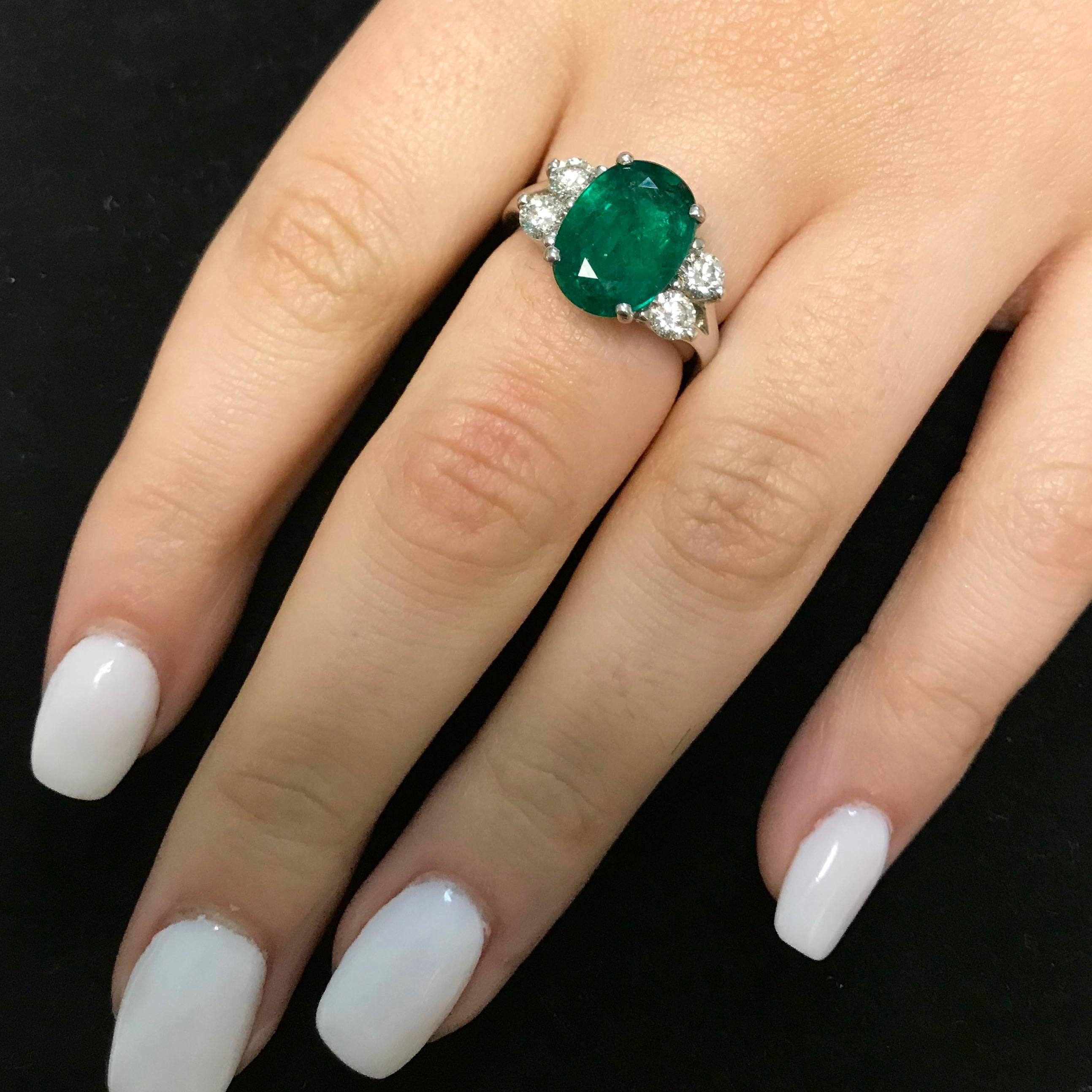 Oval Cut Oval Emerald and Diamond Side Stone Engagement Ring Split Shank 18K White Gold