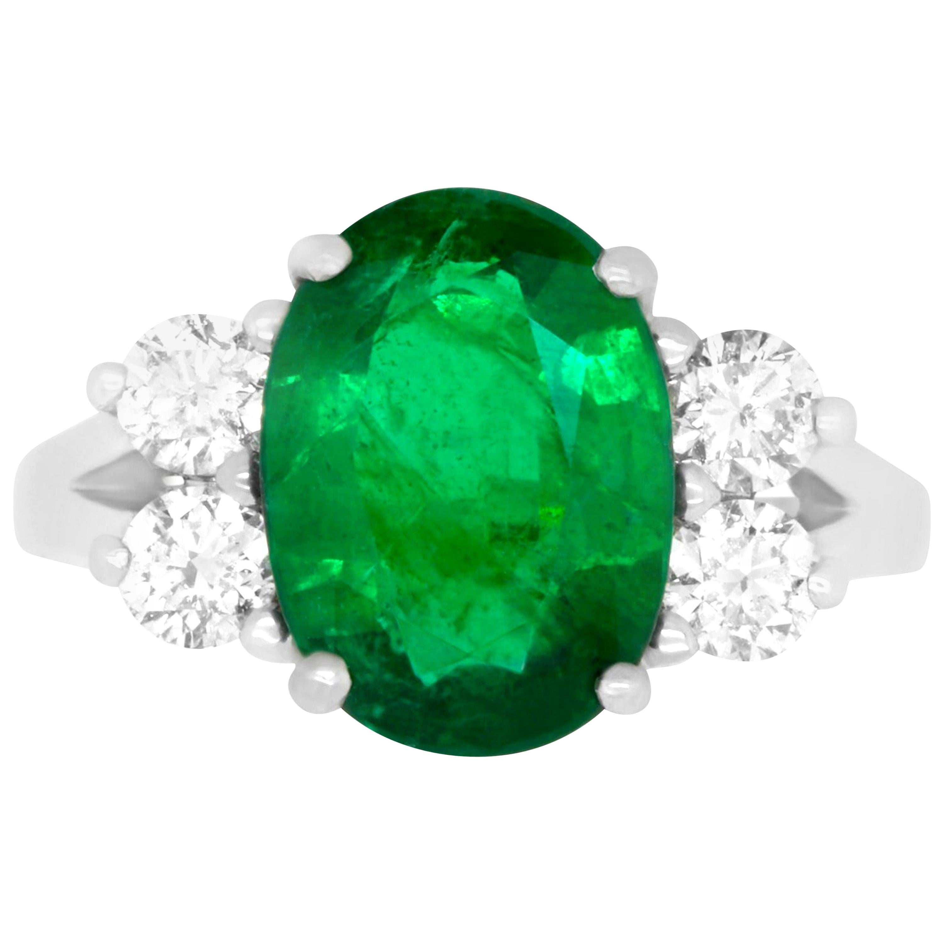 Oval Emerald and Diamond Side Stone Engagement Ring Split Shank 18K White Gold