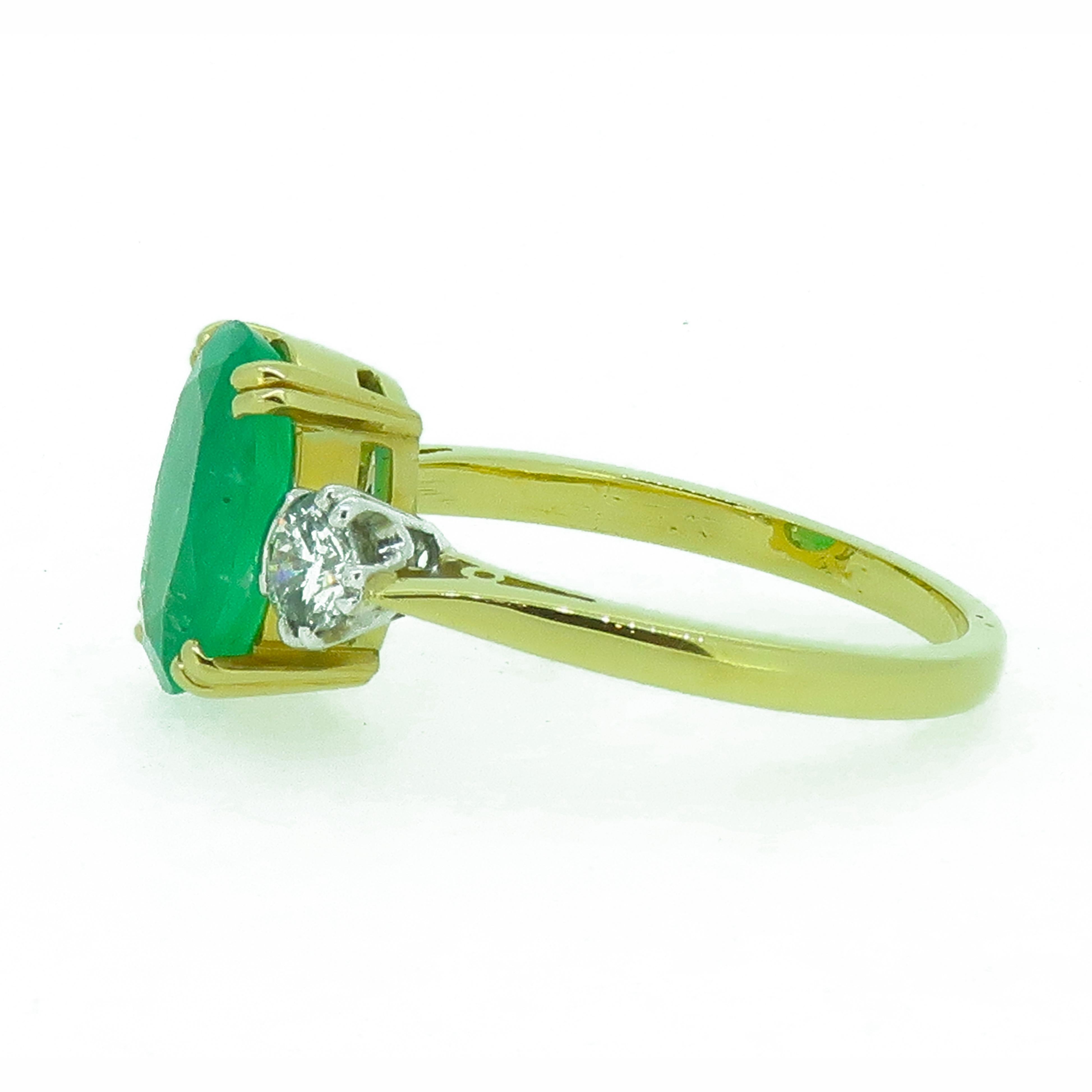 Oval Emerald and Diamond Three-Stone Ring 18 Karat Yellow and White Gold

A vibrant oval emerald & diamond 3 stone ring. Central oval emerald is a lovely vibrant bright green colour with some natural inclusions within the stone, set in four 18 carat