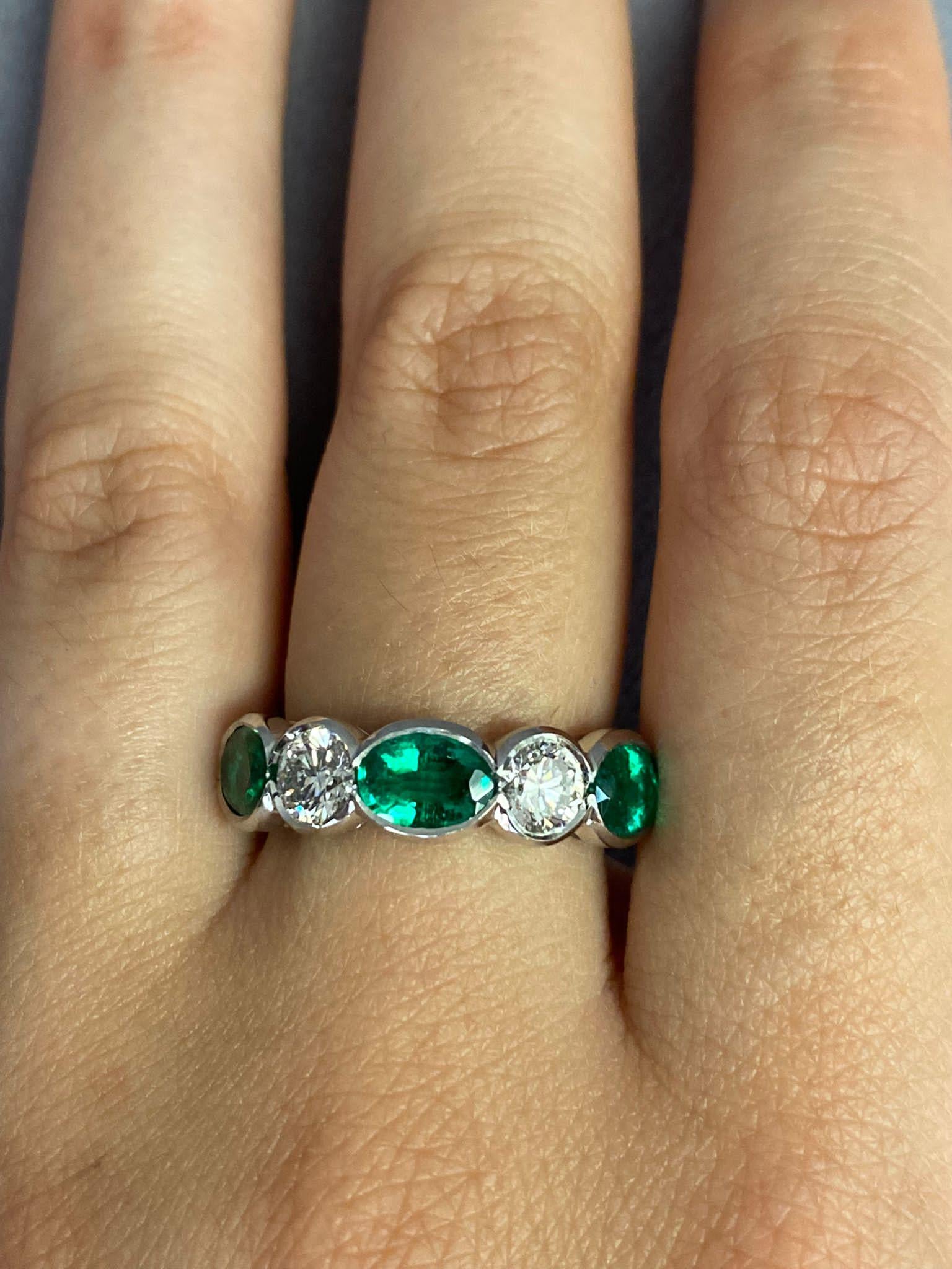 Designed as a contemporary 5 Sone Ring contrasting the Beautiful Green hue of an Oval with fiery White Diamonds. All Stones in a semi bezel for ultimate comfort and security. 
3 Oval Green Emeralds weighing 1.98 Carats spaced with 2 Round Diamonds