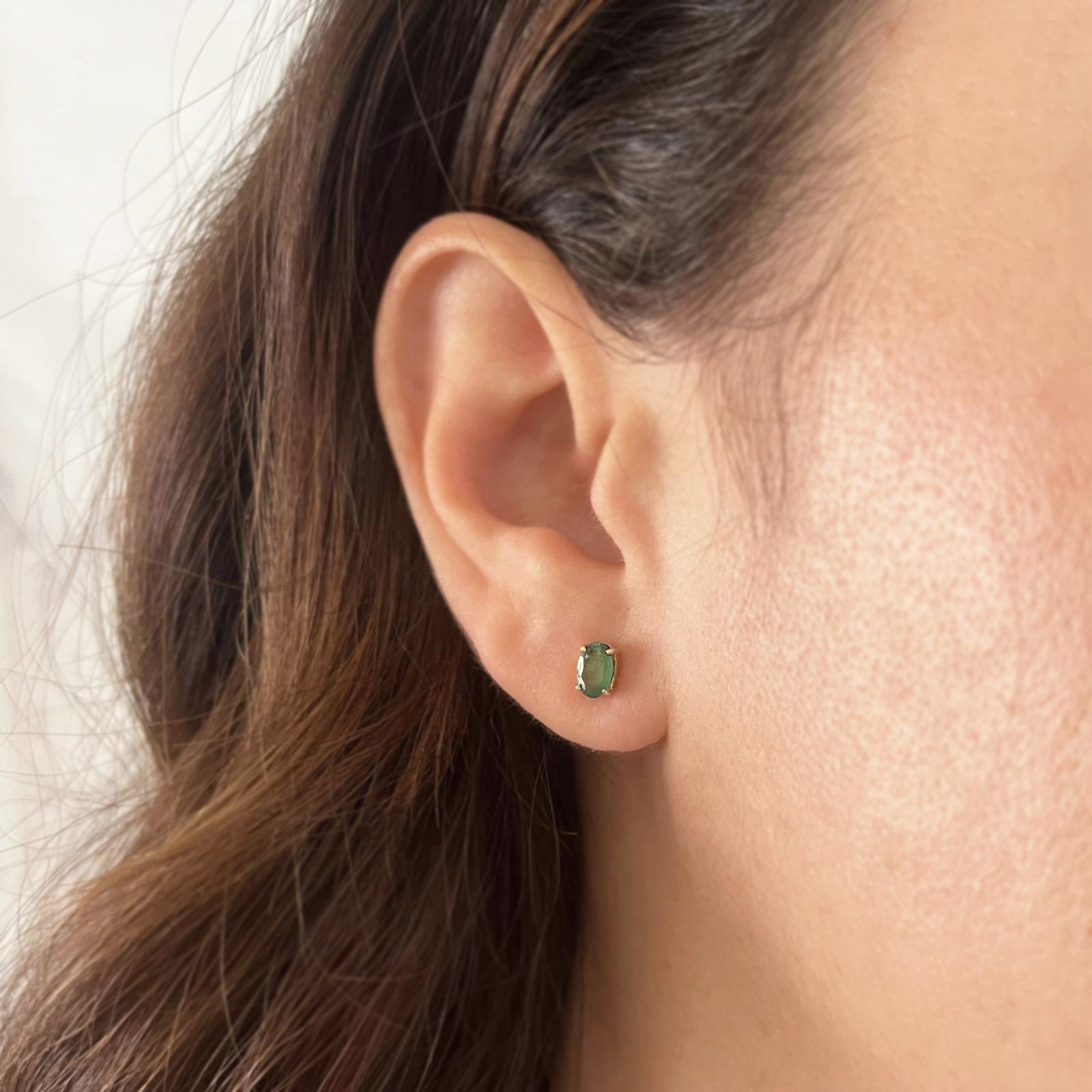 14 Karat Yellow Gold Stud Earrings Featuring 2 Prong-set Oval Emeralds Totaling Approximately 0.80 Carat. Pierced Post with Friction Back. Finished Weight is 1.0 Gram.