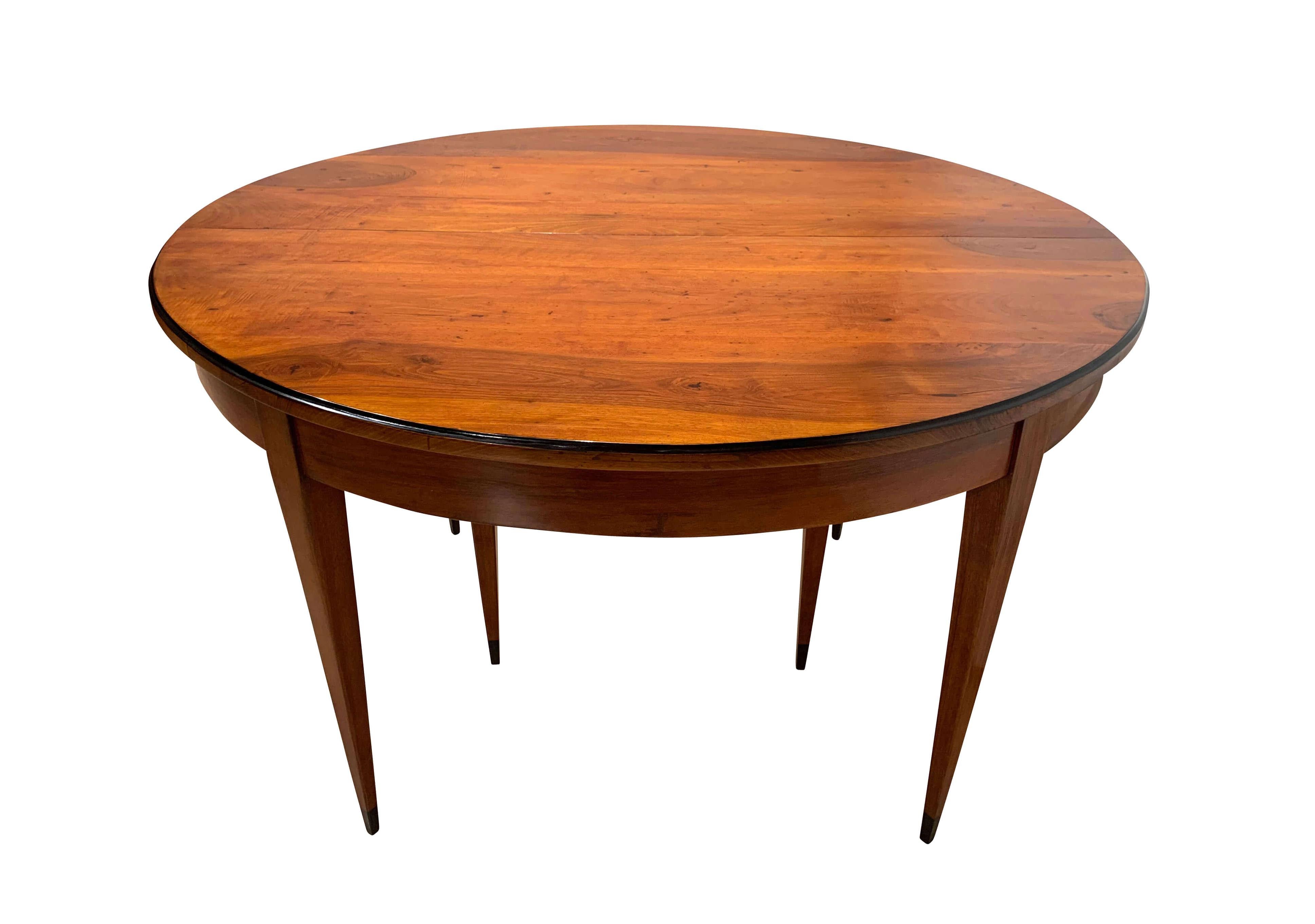 Oval expandable / extending / Pull-out dining room table, French Restauration, Walnut Wood, France around 1820.

Solid walnut and veneered. Conical square tapered legs with ebonized tips. Restored and hand-polished with shellac.
3 leaves / insert