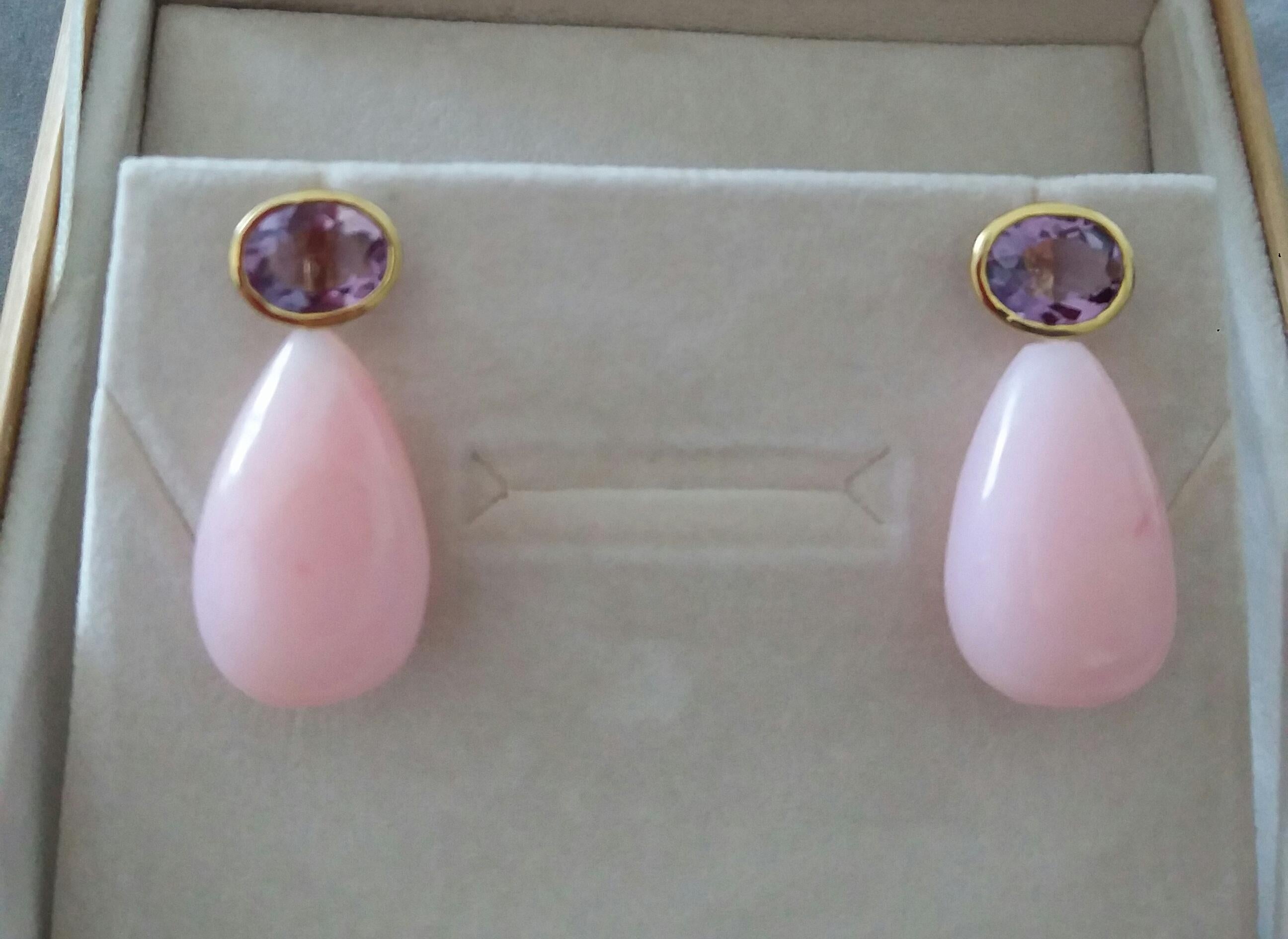 These simple but elegant earrings have 2 faceted Oval Shape Natural Amethysts size 8x10 mm set in yellow gold bezel at the top to which are suspended 2 Pink Opal Plain Round Drops measuring 16 x 25 mm.

In 1978 our workshop started in Italy to make