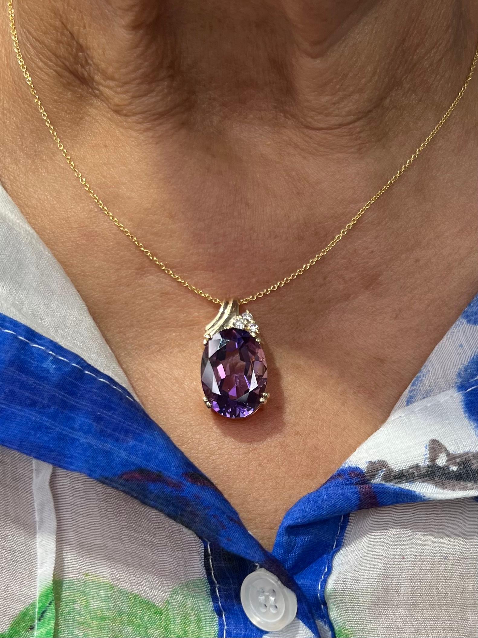 Oval Faceted Amethyst and diamond 14k yellow gold pendant circa 2000. *

Showcasing a large oval Amethyst displaying very pleasing bright color accented by a trio of round brilliant cut diamonds.  This is a more contemporary design with an