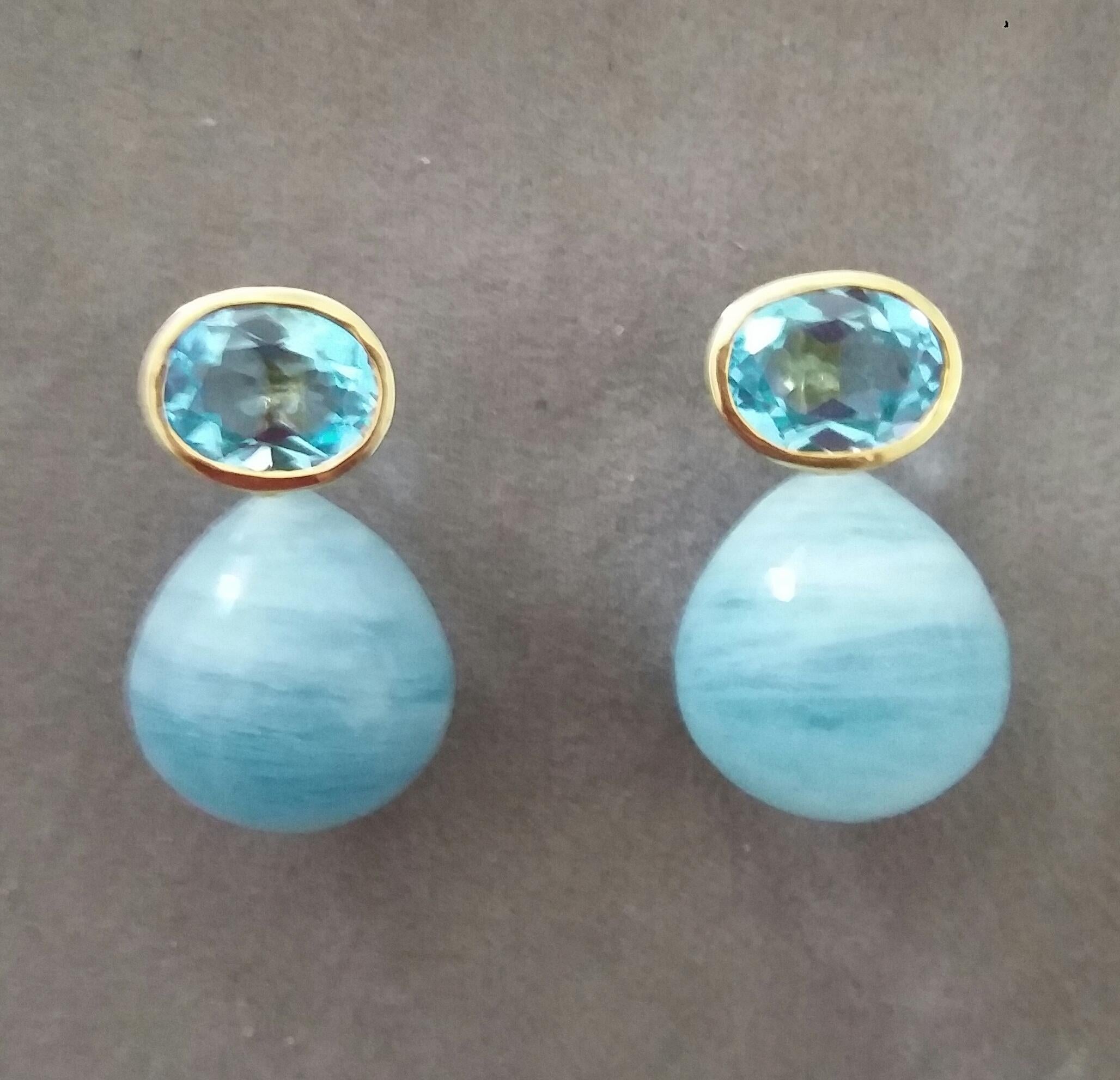 Schlichte, schicke Ohrstecker mit einem Paar himmelblauer Topase im Ovalschliff  8mm x10 mm, gefasst in massivem 14 Kt. Gelbgold, oben und unten 2 Aquamarine  Runde Tropfen mit den Maßen 15x16 mm.
1978 begann unser Atelier in Italien mit der