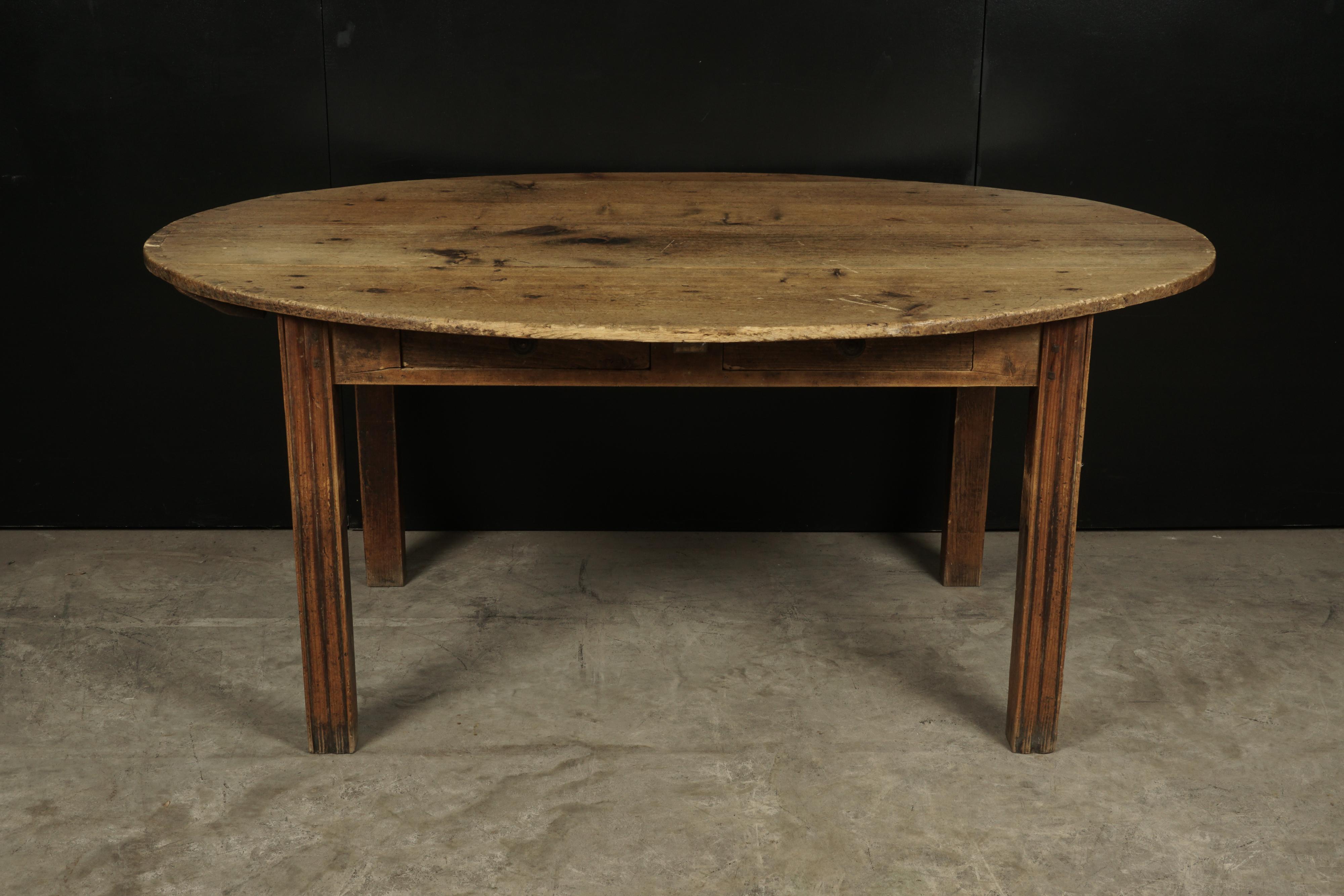 Oval farm table from France, circa 1920. Solid pine construction with two drawers.