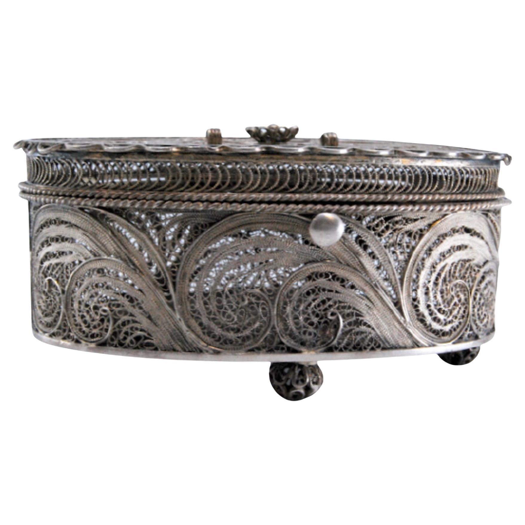 Oval filigree silver jewelry box on four feet with hinged lid en venta