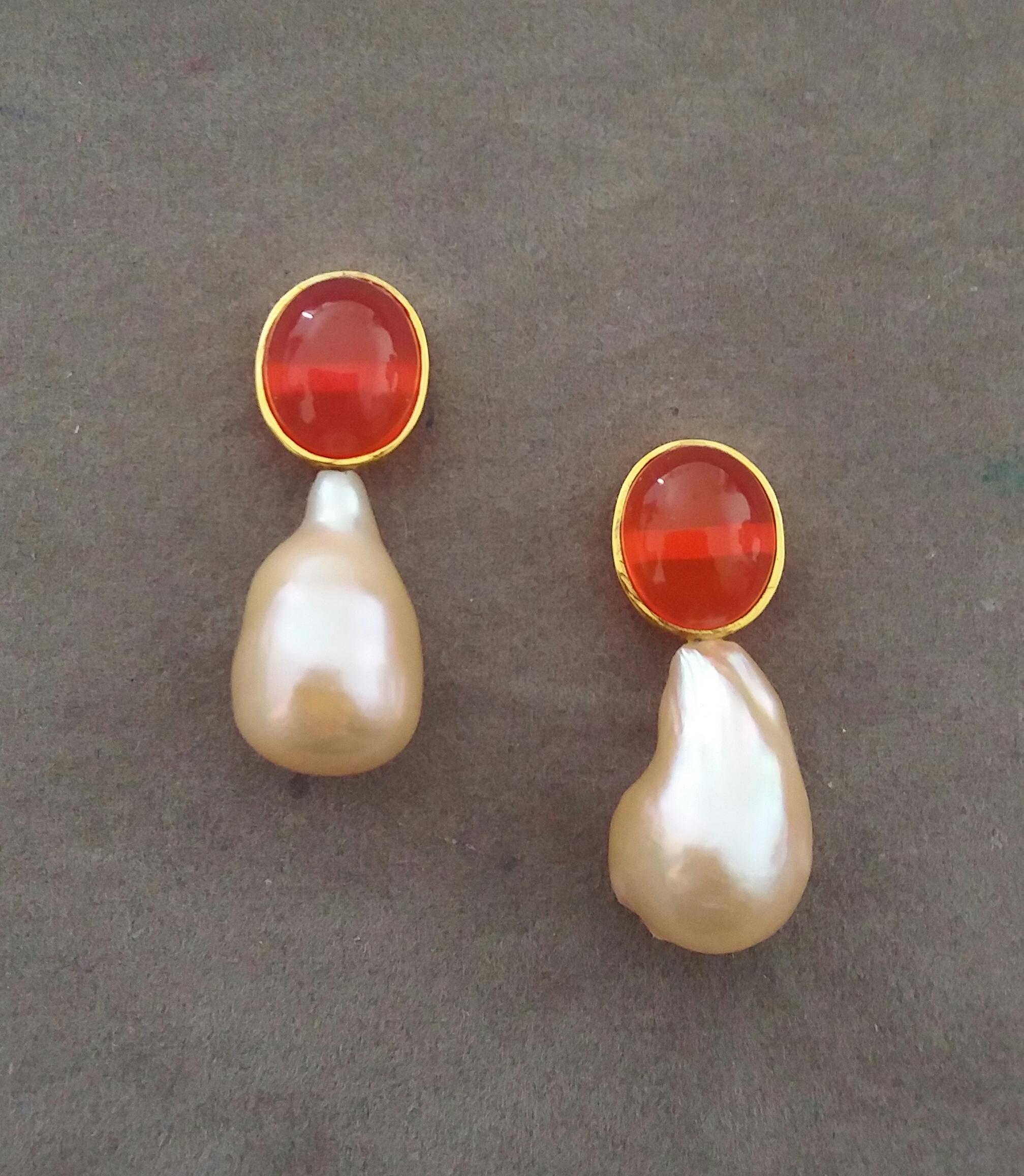These simple but elegant and completely handmade earrings have 2 Oval Fire Opal Cabochons measuring 10 x 12 mm set in 14 K yellow gold bezel at the top to which are suspended 2  Pear Shape Baroque Cream Pearls measuring 12x20 mm.

In 1978 our