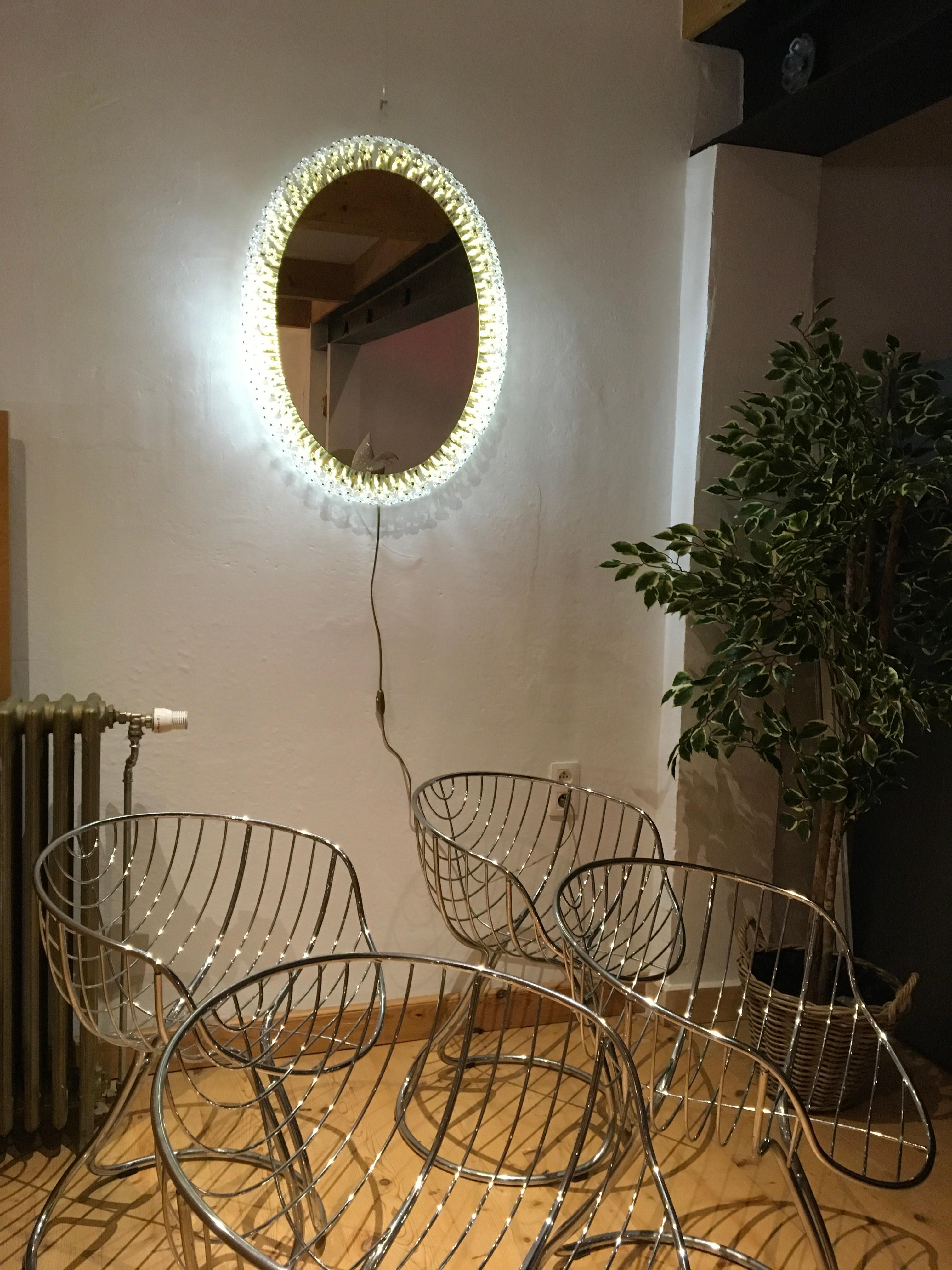 Large oval illuminated mirror with crystal flowers or blossom by Emil Stejnar for Rupert Nikoll.
This midcentury mirror has three rows of Brass Flowerstalks with Crystal Glass Flowers.
All flowers are still there. Only one flower has a tiny piece