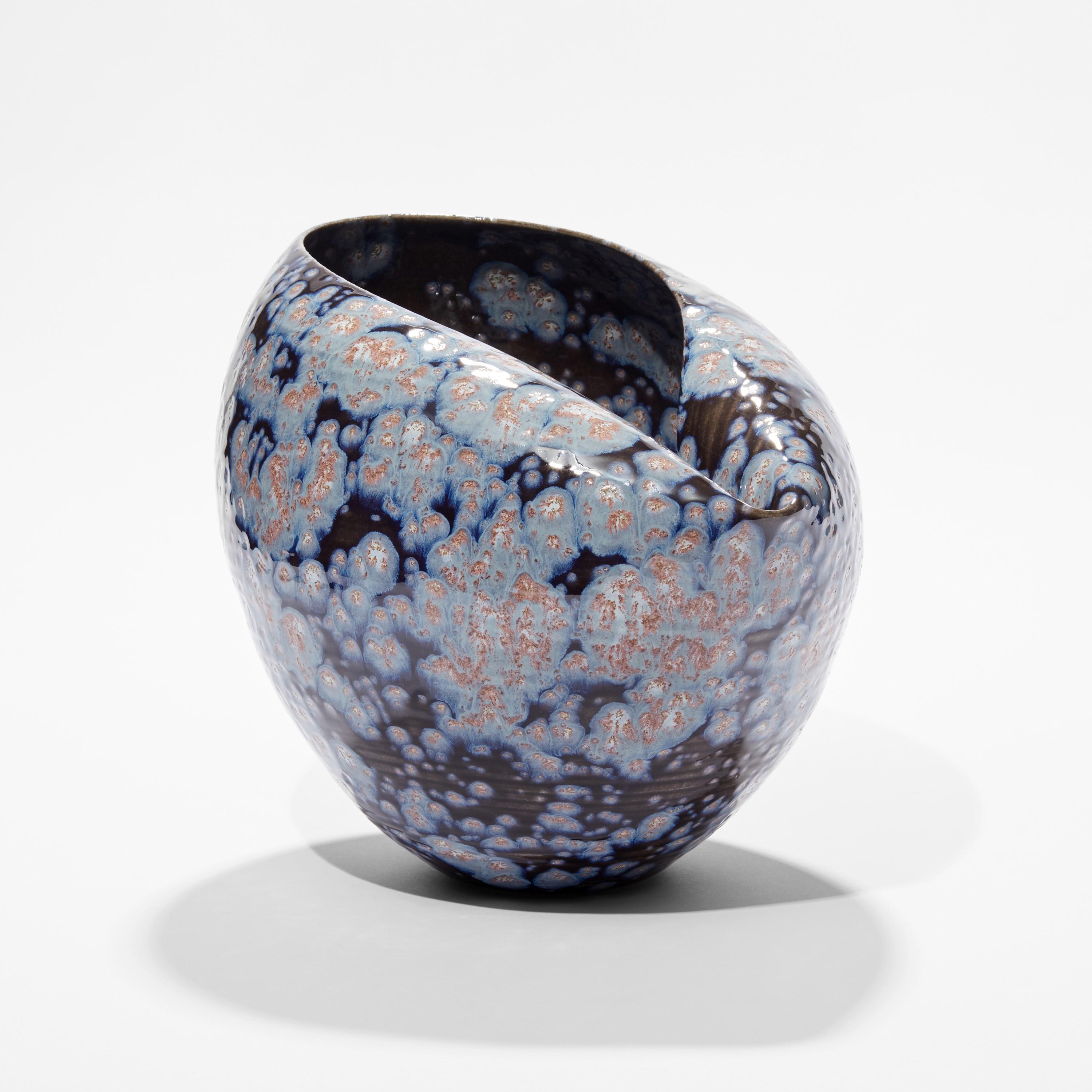 ‘Oval Form in Galactic Blue No 88’ is a unique sculptural vessel by the British artist, Nicholas Arroyave-Portela.

Nicholas Arroyave-Portela’s professional ceramic practise began in 1994. After 20 years based in London, he moved and set up his