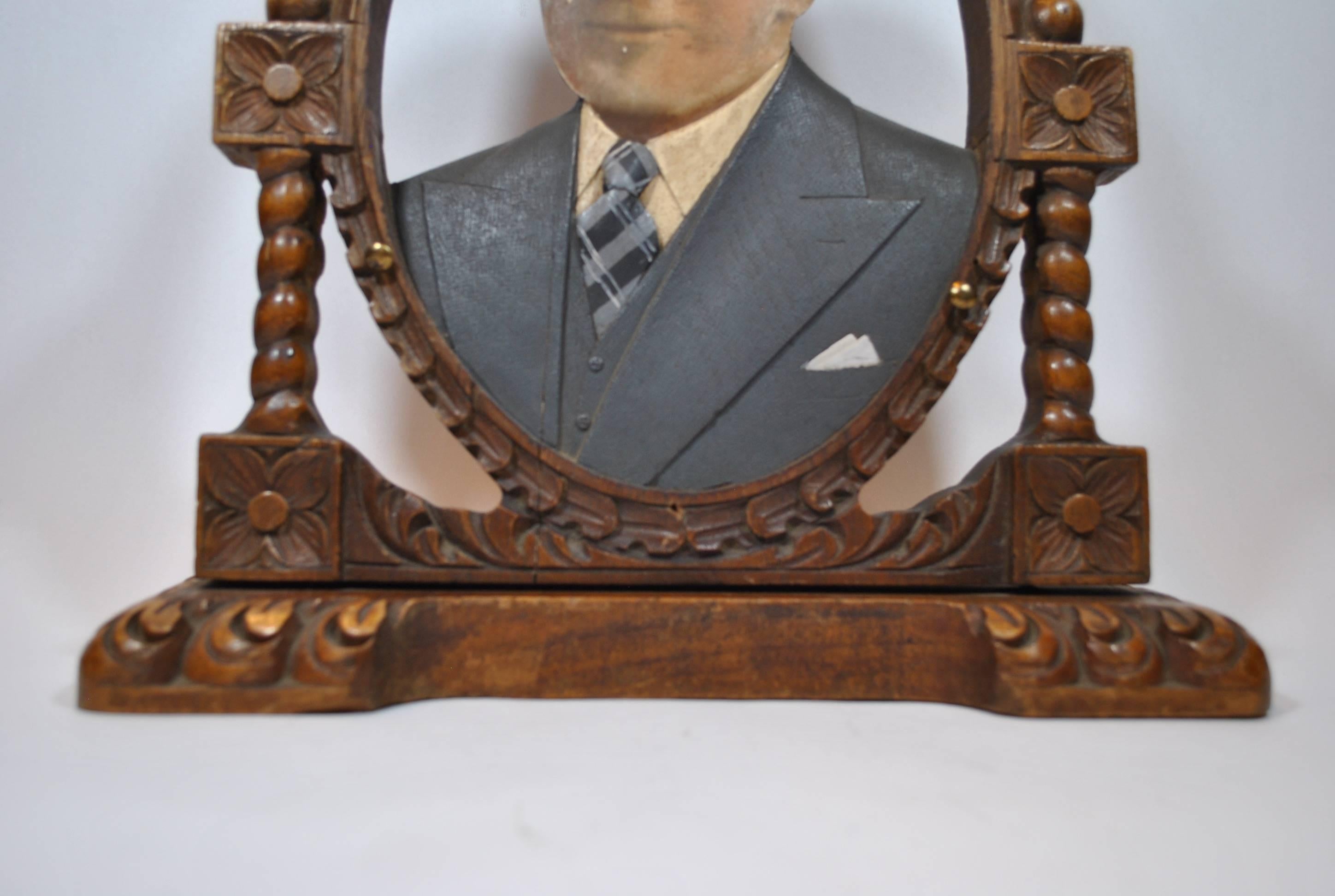 Cet objet consiste en des bustes en bois sculptés à la main avec des pièces de vêtement sculptées et peintes de manière très détaillée:: accompagnés de photographies agrandies peintes à la main de membres de la famille décédés (dans la plupart des