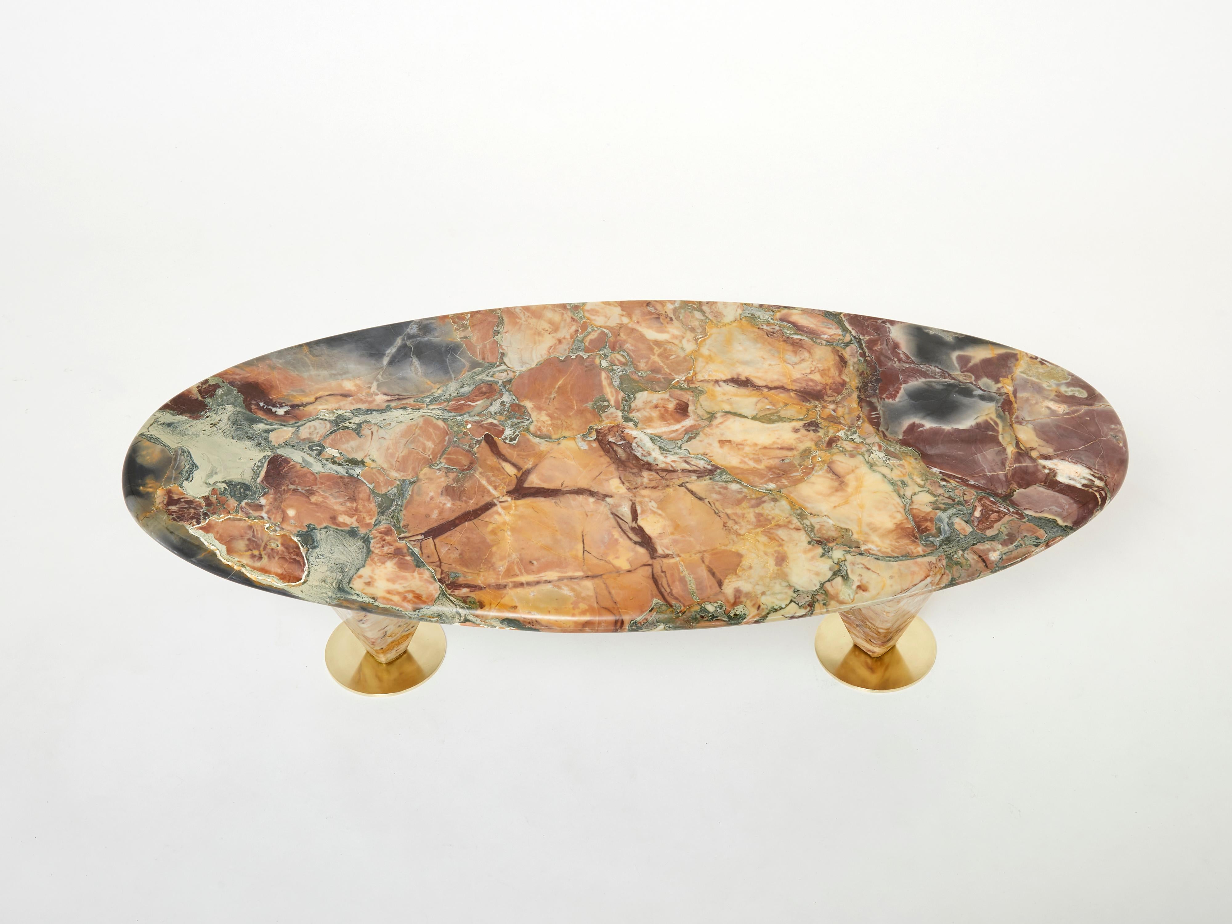 Beautiful oval shaped with free form feet coffee table made in France in the early 1980s from a beautiful Pyrénées marble called Brèche de Benou or Brèche de Vendôme. Each foot, in solid marble, is finished by a solid brass disk. The Brèche du Benou