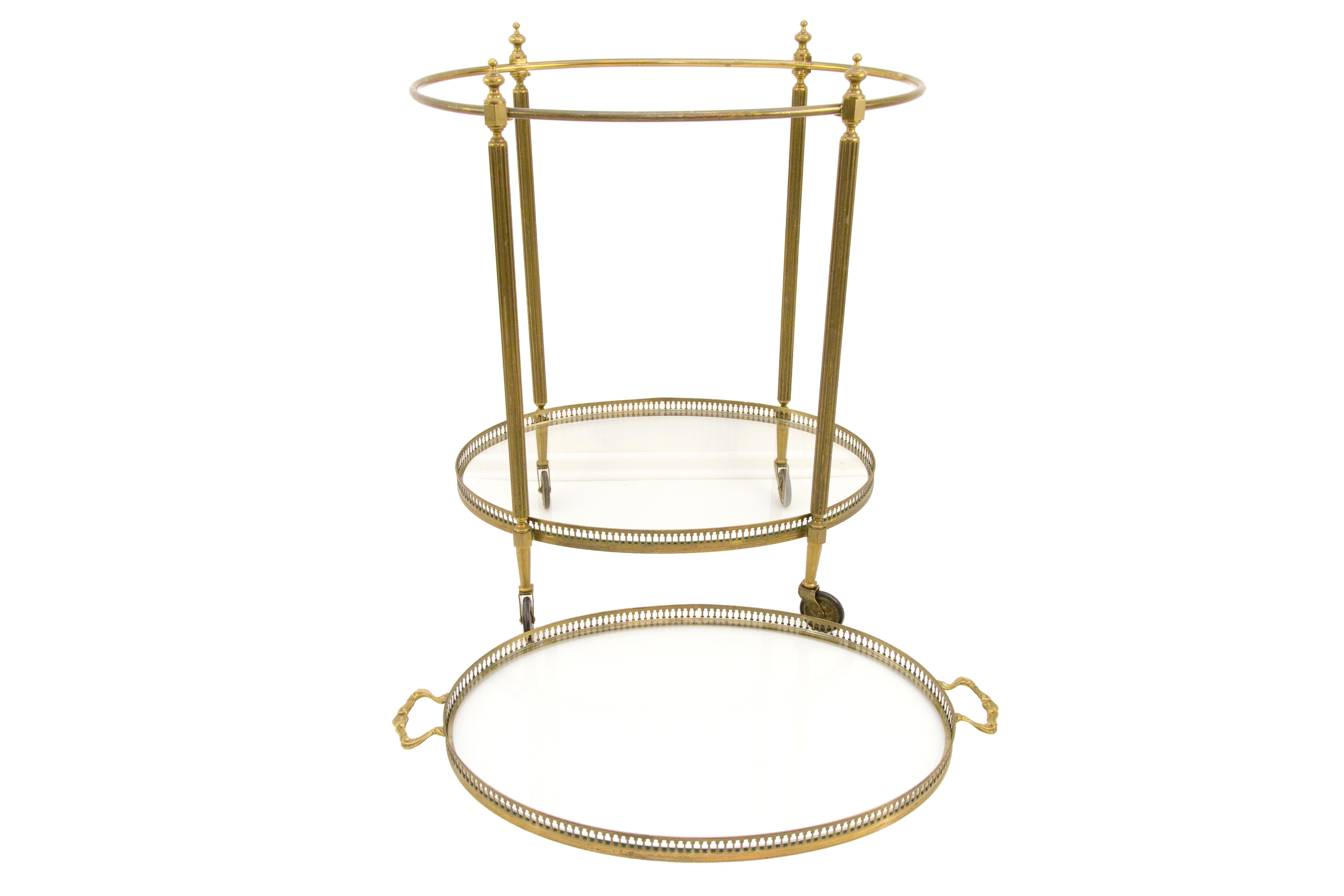 Elegant oval bar cart made of brass, bronze and glass in 1940s, France, attributed to Maison Baguès. The cart features 2 clear glass tops with brass galleried edges, serving tray is removable.
Measures: Height: 67 cm / 26.3 in, width 40 cm / 15.7