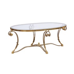 Ovaler französischer Couchtisch aus Stahl und Messing mit Glasplatte, Huffüßen und Eicheldetails