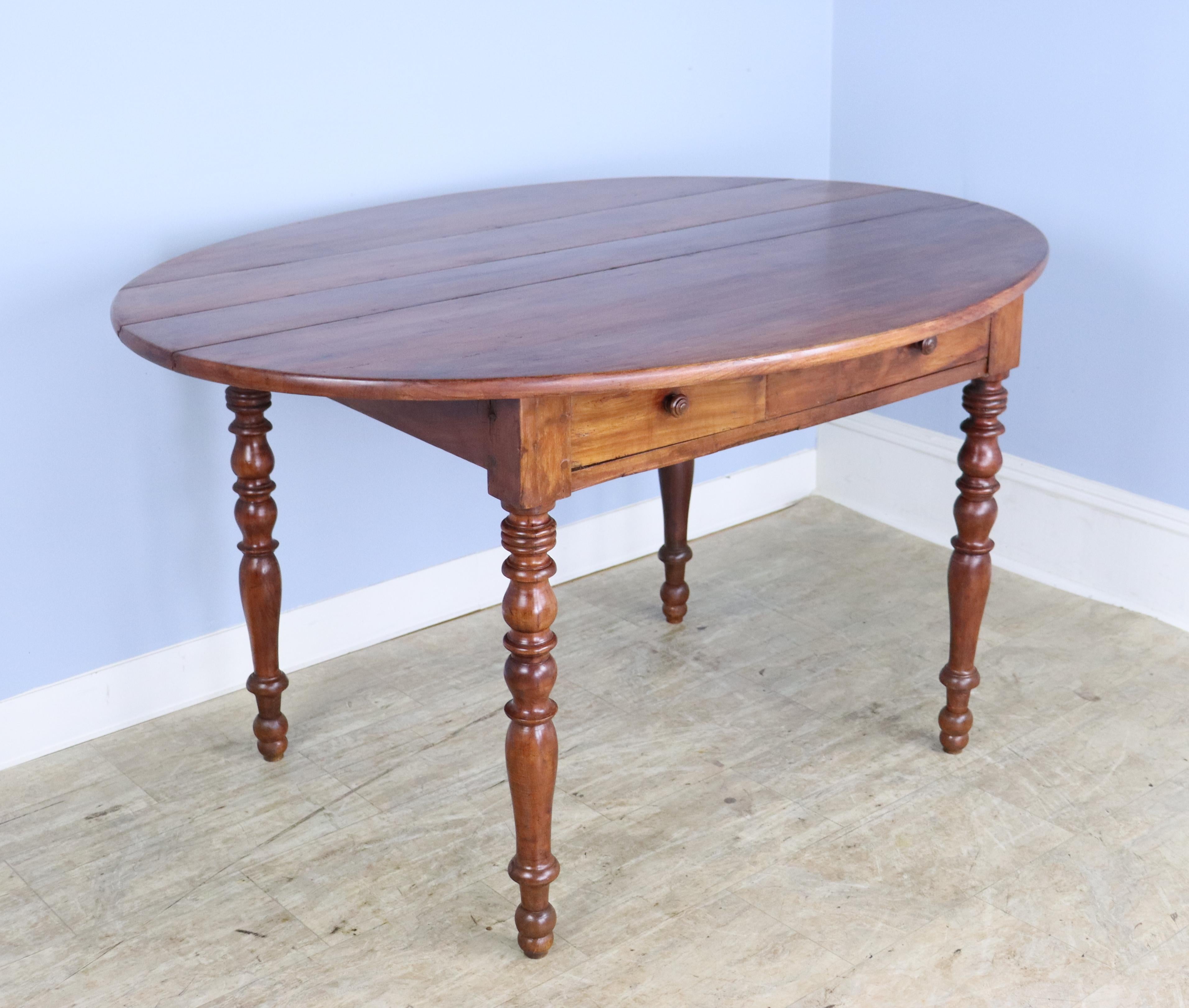 A pretty and practical oval fruitwood breakfast or occasional table with glossy turned legs. Both the top and the legs have good patina and wood grain. Two useful drawers in the apron.