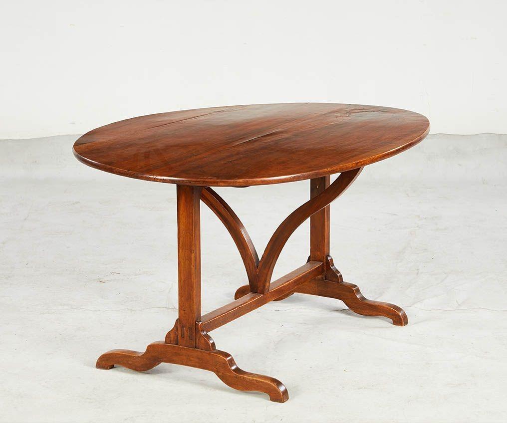 Table de vigne du 19ème siècle avec un plateau ovale en bois fruitier soutenu par une harpe sinueuse et reposant sur des pieds traîneaux aux orteils courbés. Comme il est d'usage pour ce type de table, le plateau s'incline à la verticale pour