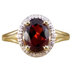 Oval Garnet and Diamond Illusion Halo Cluster Ring in White and Yellow Gold