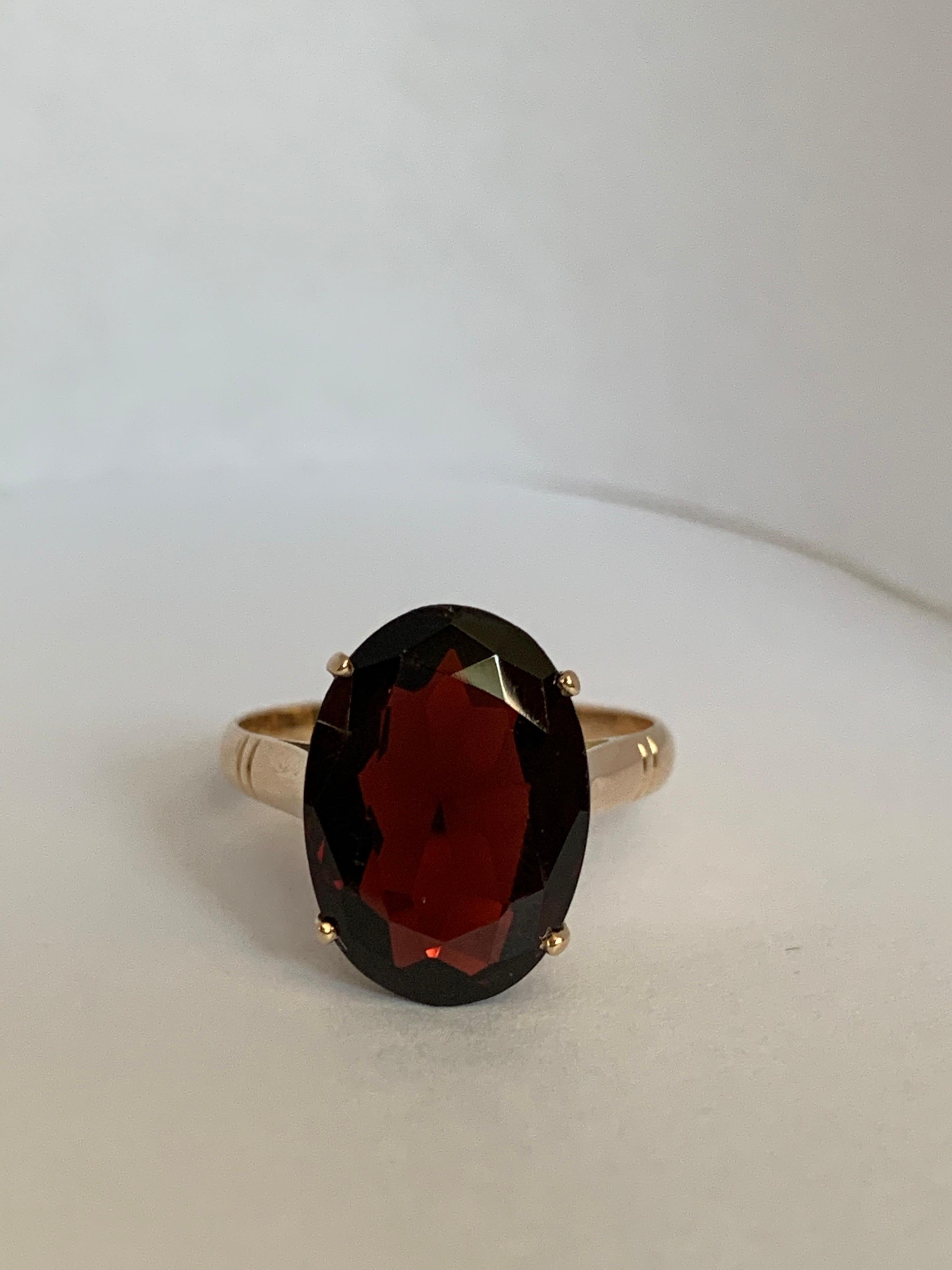 Oval 10 mm X 14 mm Garnet set in 14 Karat yellow gold ring is 100%hand crafted ring and the stone is hand cut and polished. The ring is one of a kind and sizable 6.75.