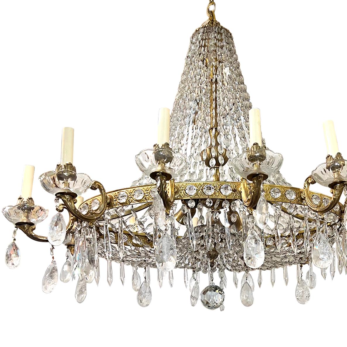 An oval circa 1920 French gilt bronze and rock crystal neoclassic style chandelier. 

Measurements: 
Height: 39 in. (adjustable drop)
Depth: 30 in.
Width/length: 38 in.