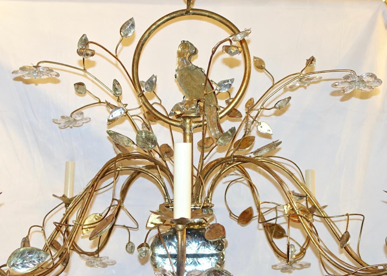 A French eight-arm oval gilt metal chandelier with molded glass leaves and bird on body, circa 1940.

Measurements:
Length 44