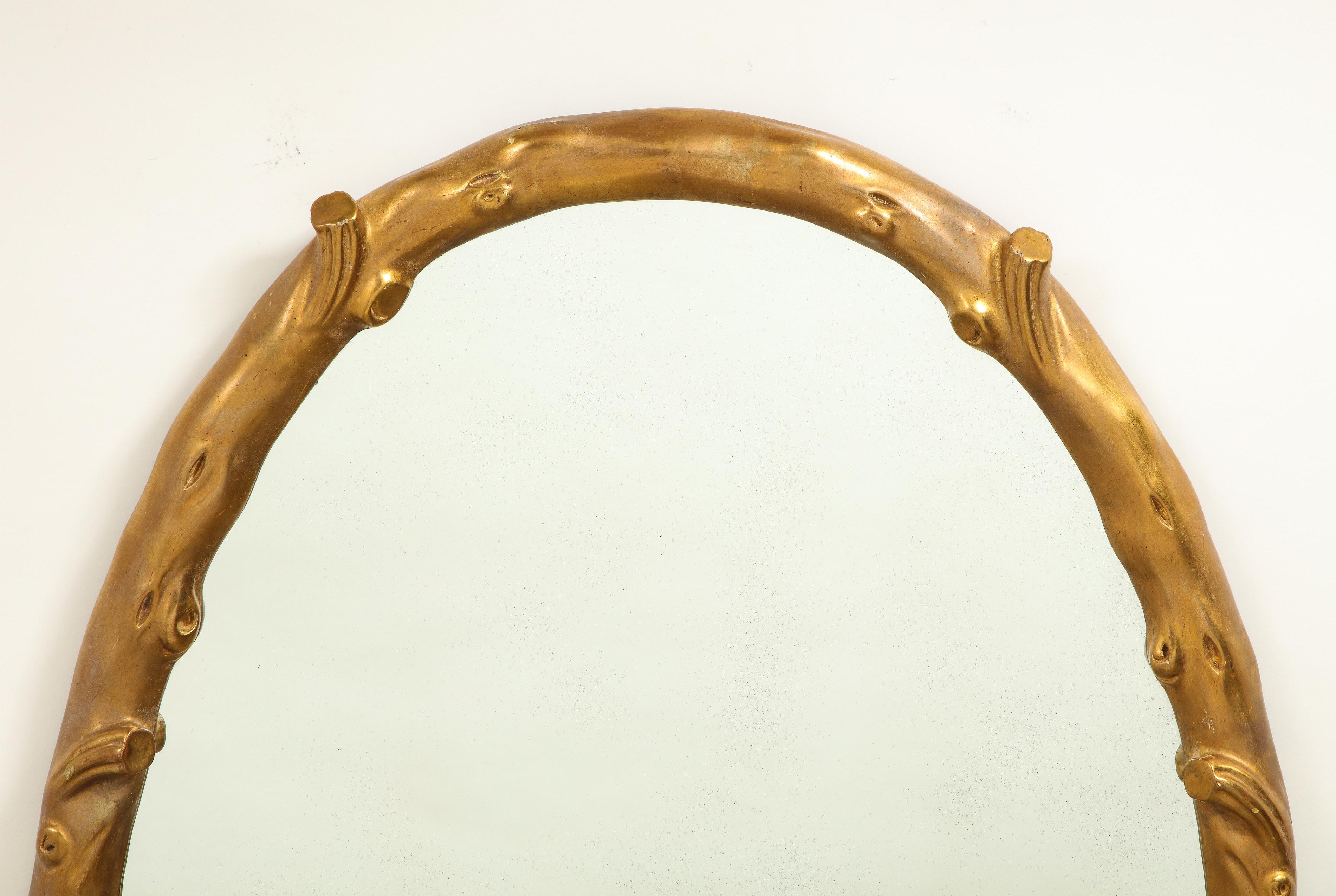 The mirrored plate within a conforming surround fancifully carved to look like a tree branch.
