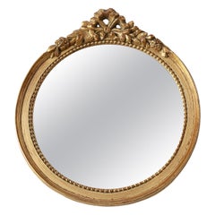 Oval giltwood mirror with rococo-style floral crest, mid-20th century