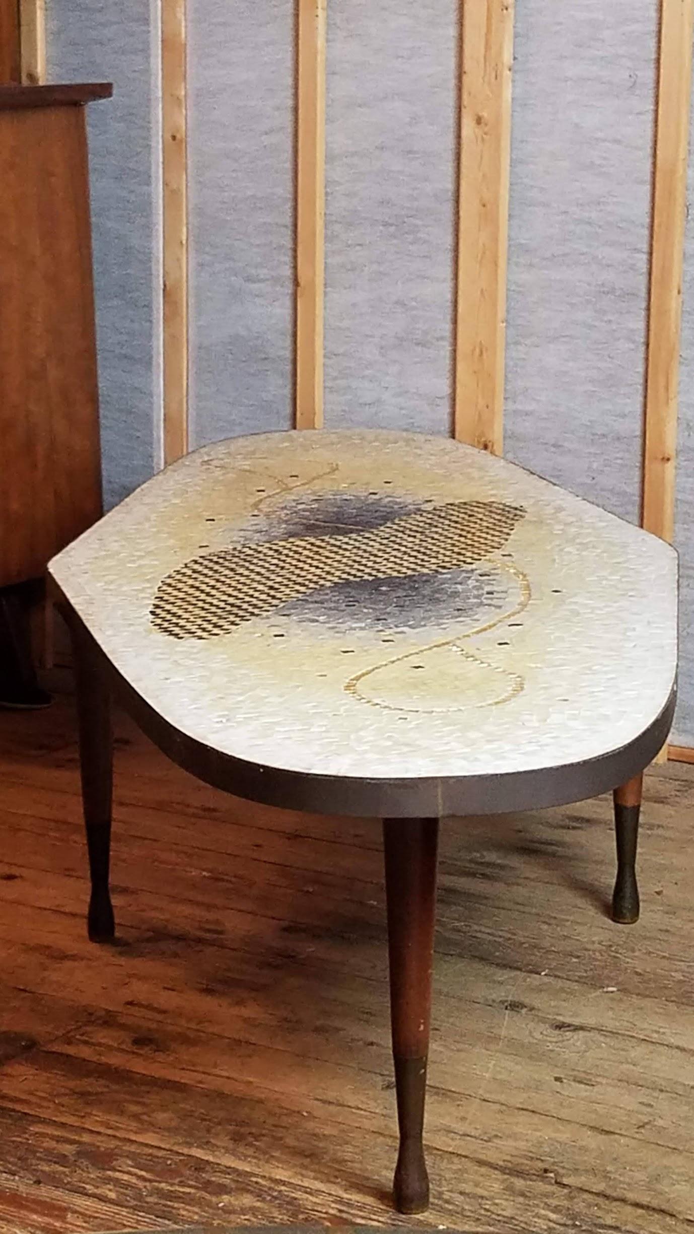 An unusual mosaic coffee table created in glass tile by Genaro Alvarez and handcrafted at his studio in Mexico City in the late 1950's.
There are three different compositional designs in the creation of this mosaic top.
The first is the abstract