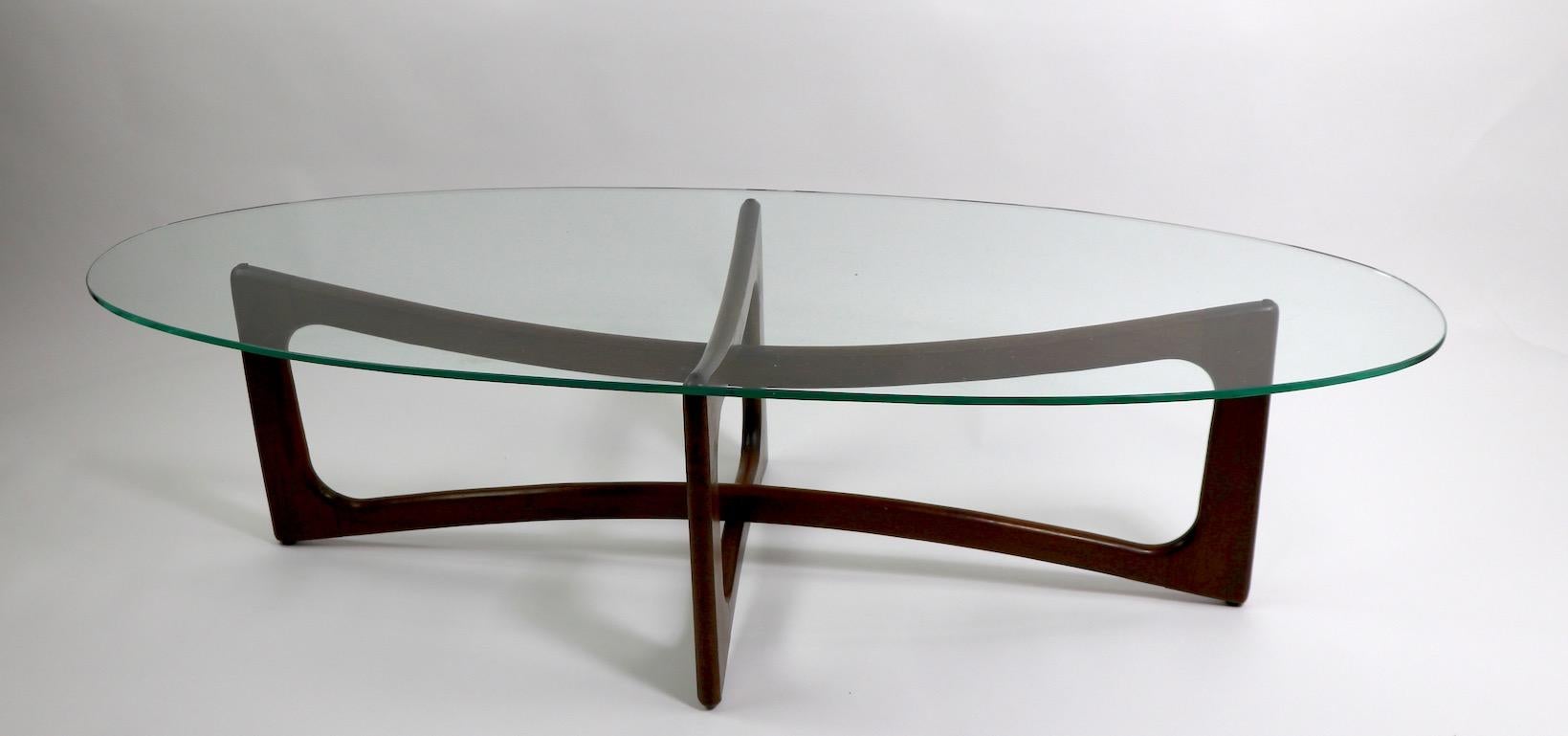 Iconic and Classic Pearsall surfboard glass top coffee table with oval glass top ( .25 inch thick ) and interlocking sculpted wood legs. Original, clean condition, plate glass top has a very small pock mark (pictured) and normal wear consistent with
