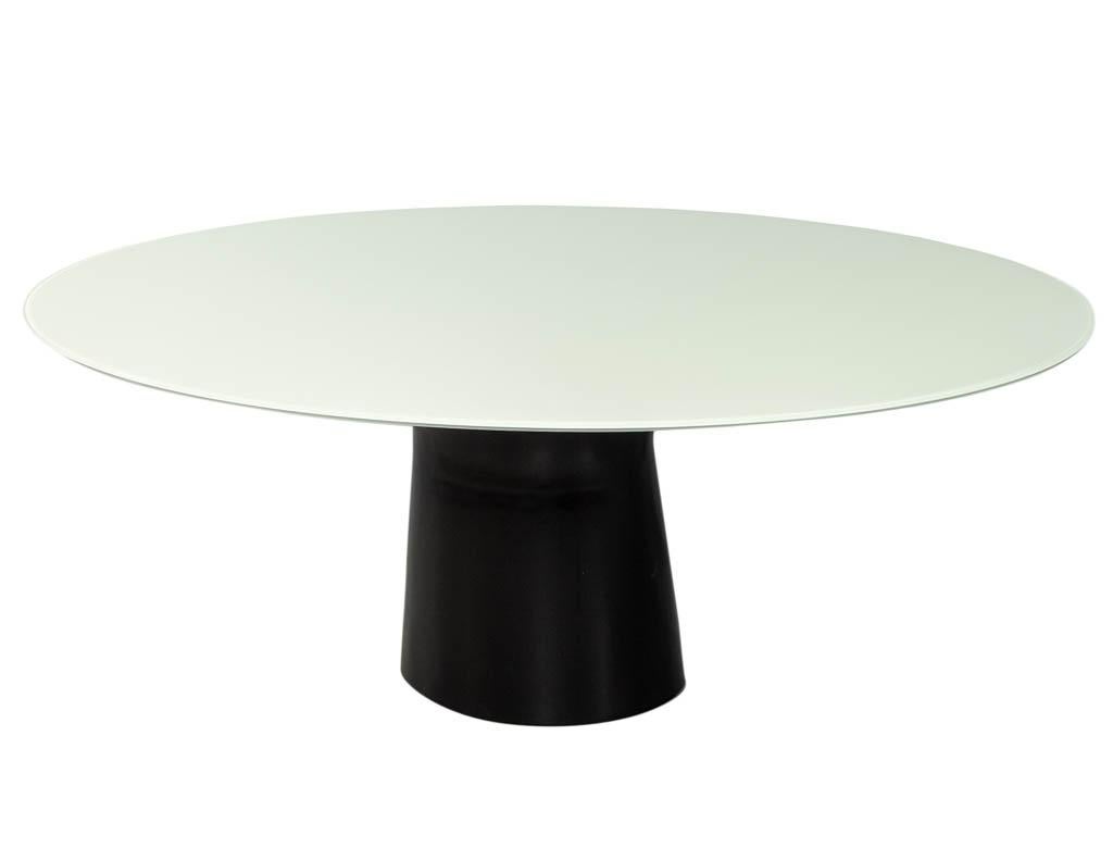 Carrocel Custom made oval glass top dining table with a Custom Designed Solid Wood Pedestal Base in a cyclone design. Finished in a Charcoal Lacquer and topped with a back painted white oval glass.
