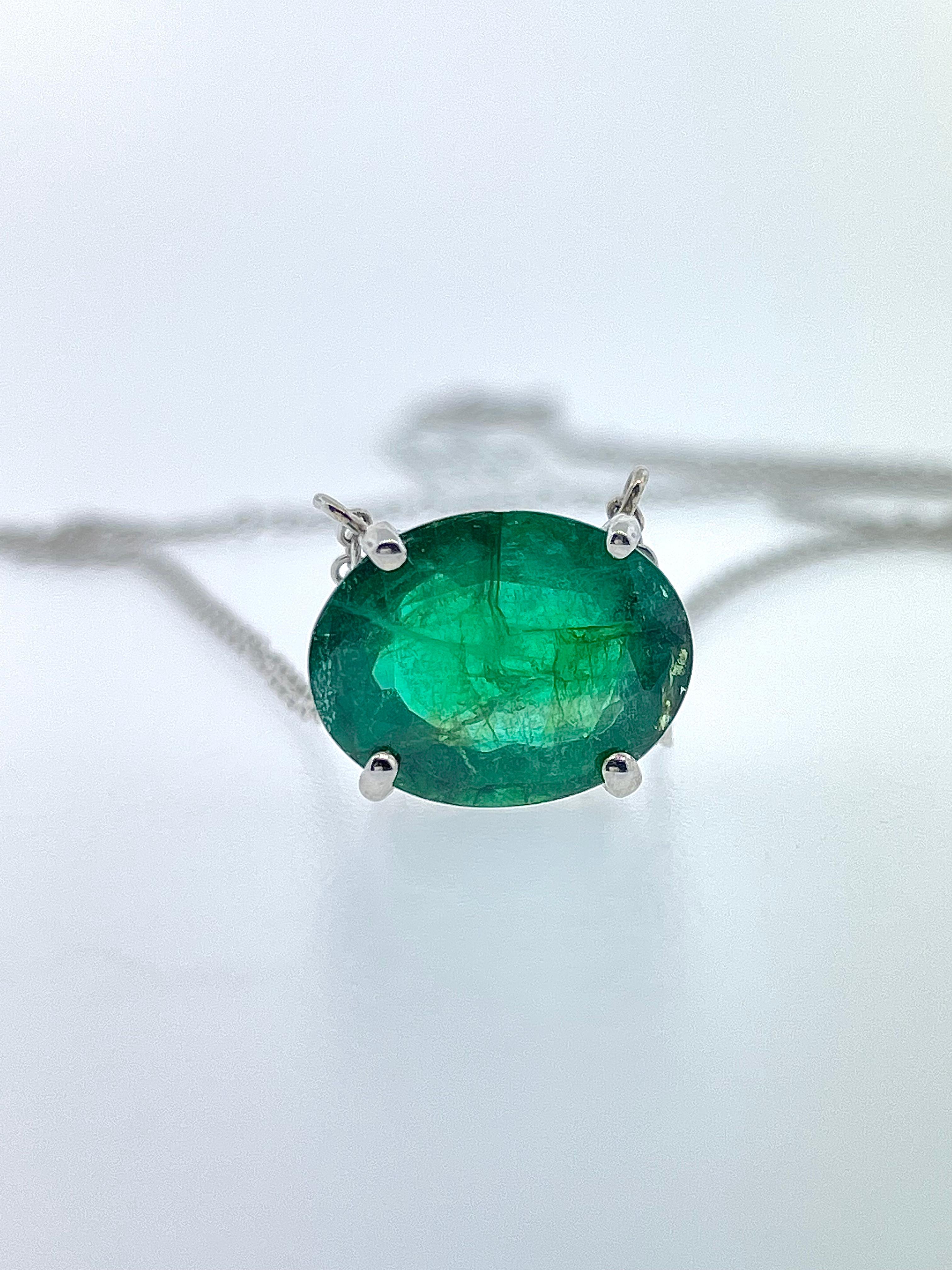 This beautiful necklace contains one oval green emerald weighing 6.96 carat total weight set in a four-prong basket. It is attached to a 17