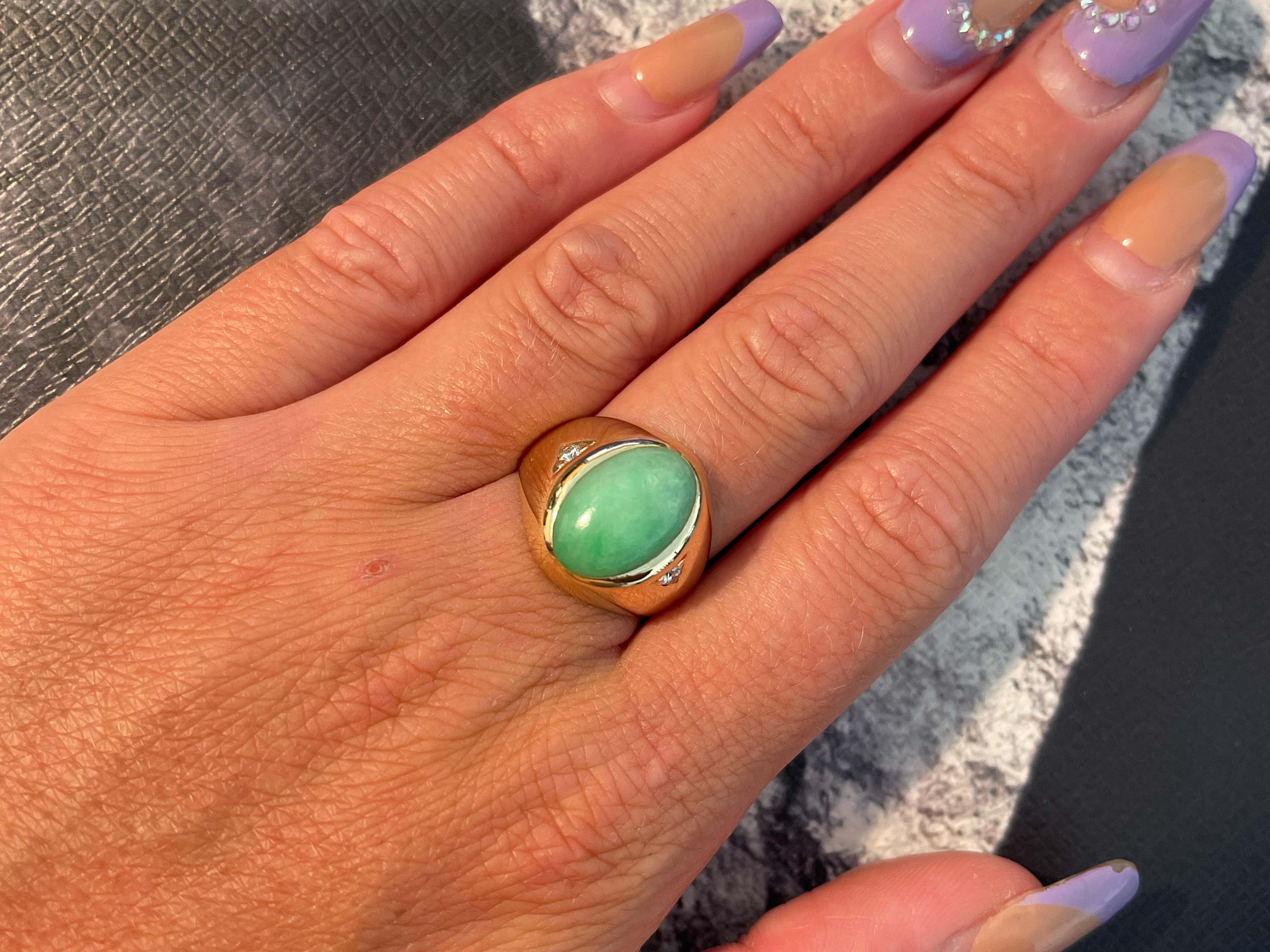 Ovaler Ring aus grüner Jade und Diamant in 14k Gelbgold. Diese atemberaubende Jade hat eine einzigartige grüne Farbe mit schöner Transluzenz. Die Jade misst ungefähr 14,99 mm x 9,76 mm x 4,22 mm. Der Ring hat insgesamt 2 Diamanten. Das Gesamtgewicht