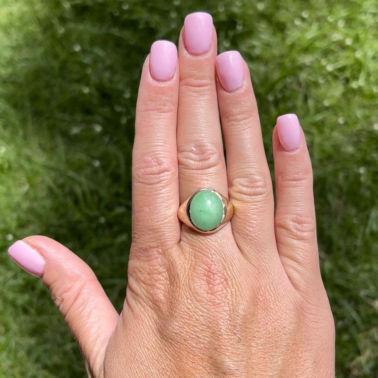 Oval shape cabochon green jade ring, bezel set in 14k yellow gold. The Jade measures approximately 17.06 mm x 12 mm x 6.02 mm with an estimated weight of 9.01 carats. The ring has a rounded tapered shank with a high polish finish. The ring is size