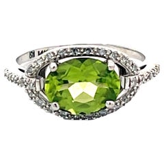 Ovaler grüner Peridot und Diamant-Halo-Ring aus 14 Karat Weißgold