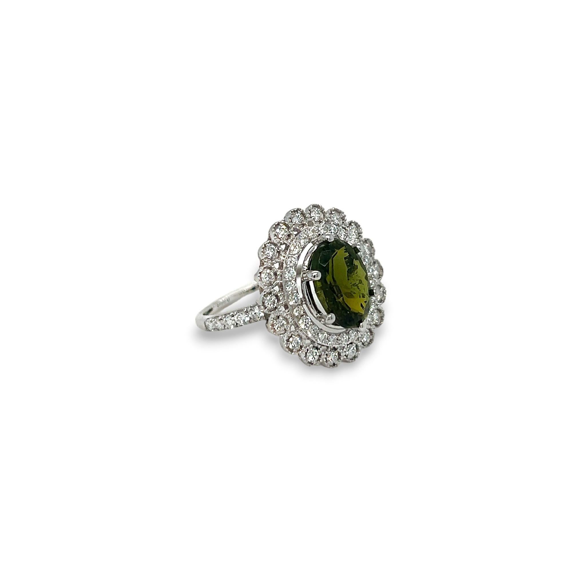 Cette magnifique bague est ornée d'une tourmaline verte ovale de 3,77 ct. La pierre centrale est rehaussée par un total de 0,85 ct de diamants ronds de couleur G/H et de pureté SI.  La bague est fabriquée en or blanc 14k et peut être dimensionnée à