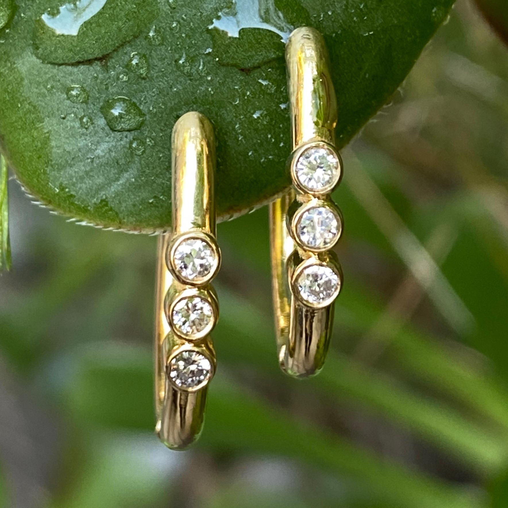 These snappy hoops by Eytan Brandes feature trios of bright white diamonds playfully set in bulgy little bezels.

The diamonds are natural, earth-mined and untreated rounds, brilliant cut with a weight per stone of 0.04 carats.   Eytan rates them