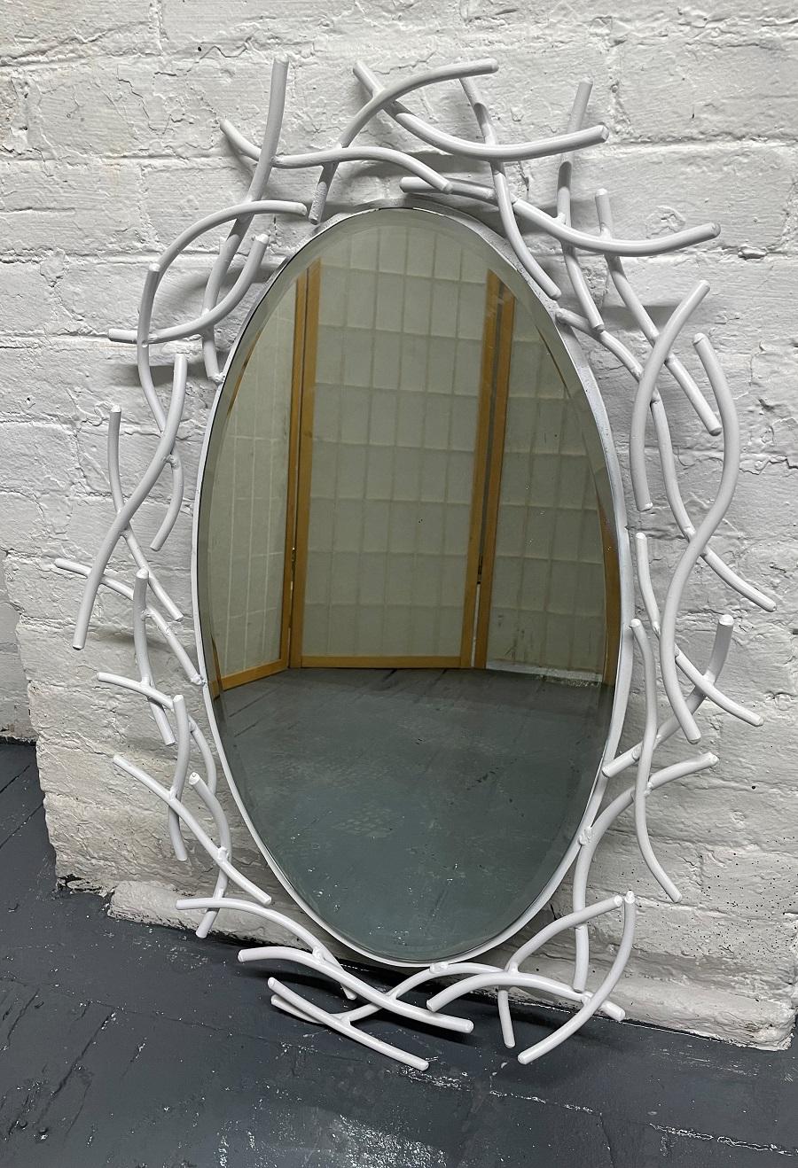 Painted oval iron mirror. White painted frame depicting twigs.