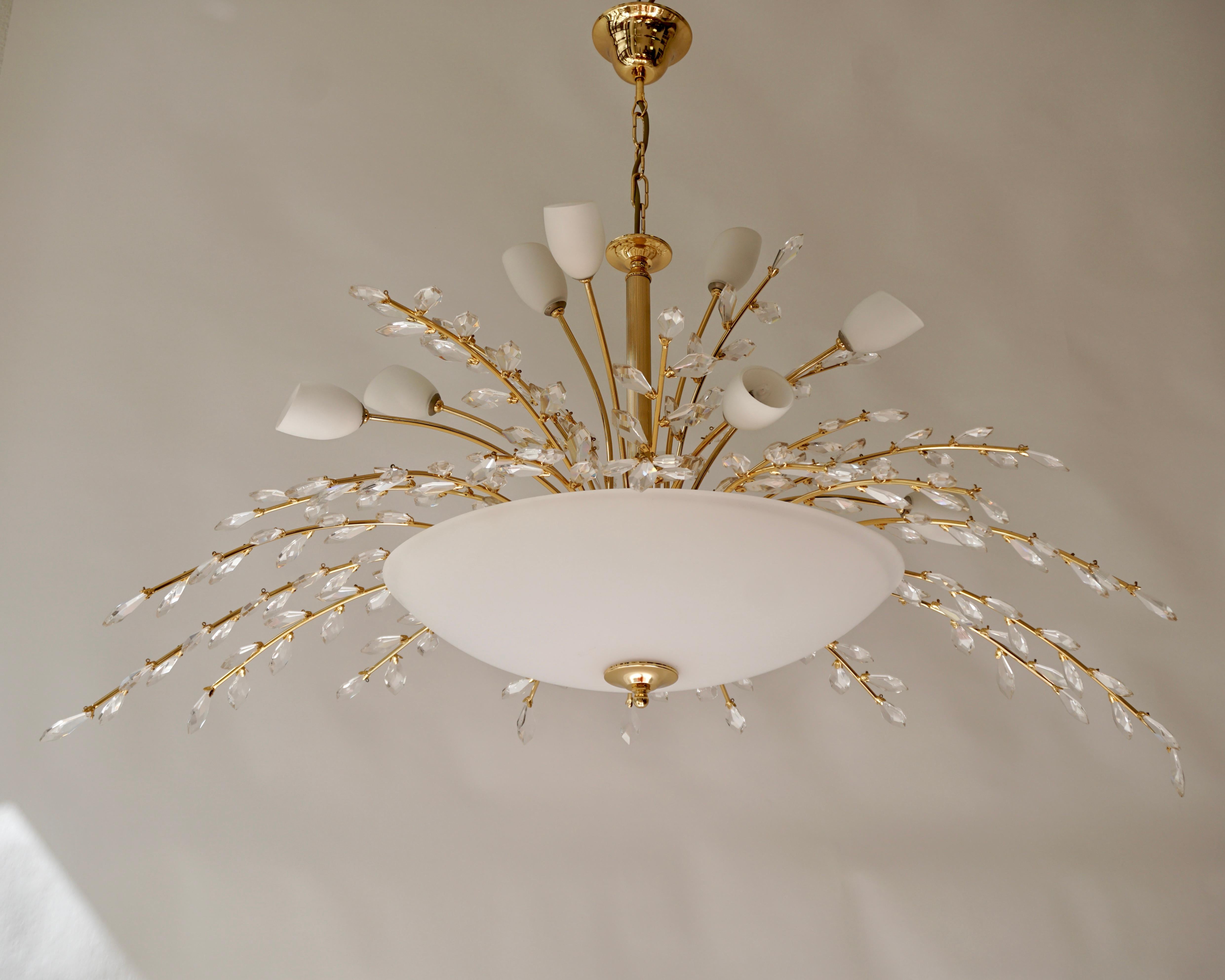Large oval Italian chandelier is brass and opaline glass.

The chic, contemporary design of this magnificent chandelier combines traditional crafting techniques with a modern design approach. Simple and elegant lines create an oval silhouette