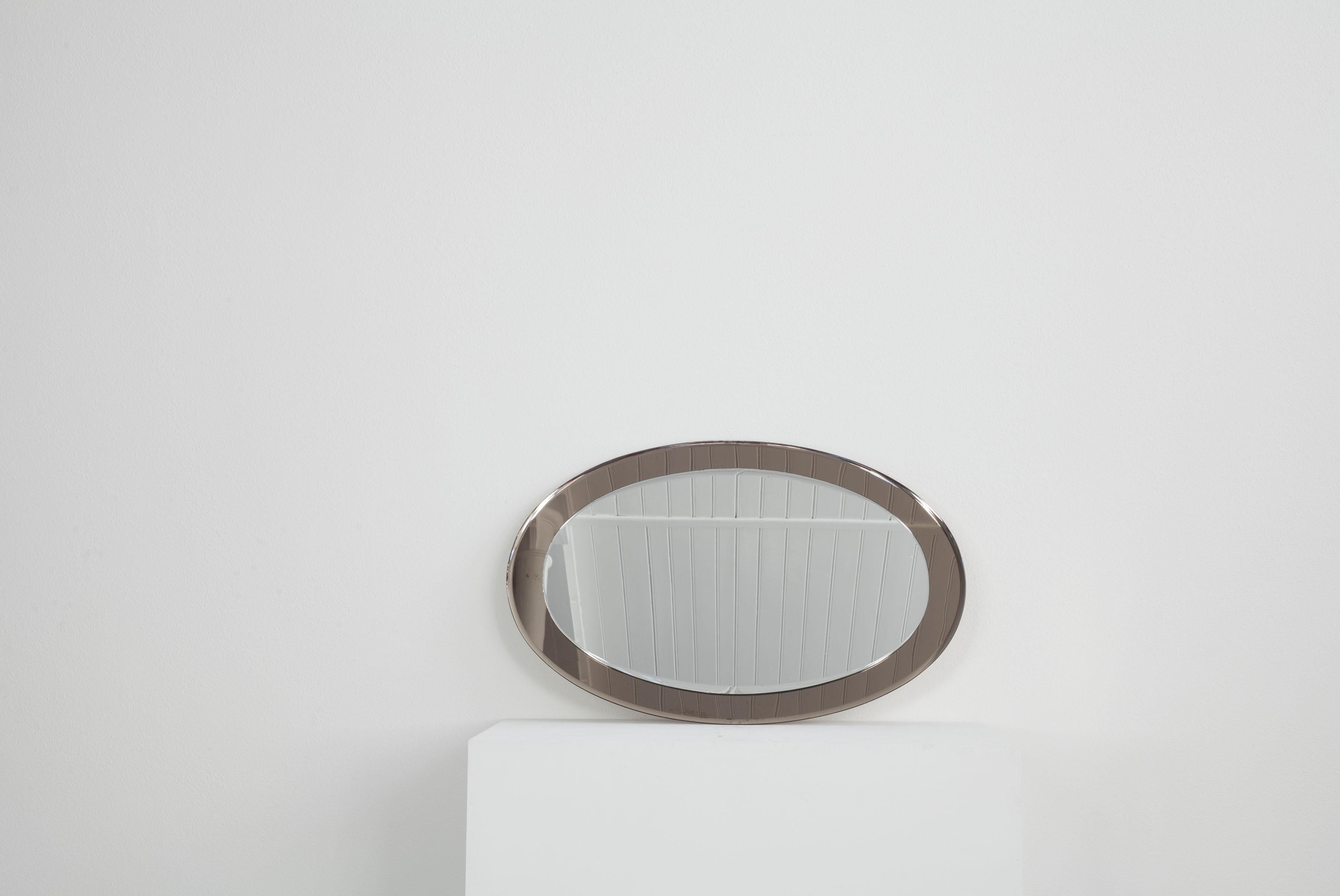 This oval, Italian wall mirror dates from the 1960s. The special thing about this mirror is the frame, which is also made of reflecting glass, but is slightly darker, greyish in colour. The mirror is in good condition.

 

