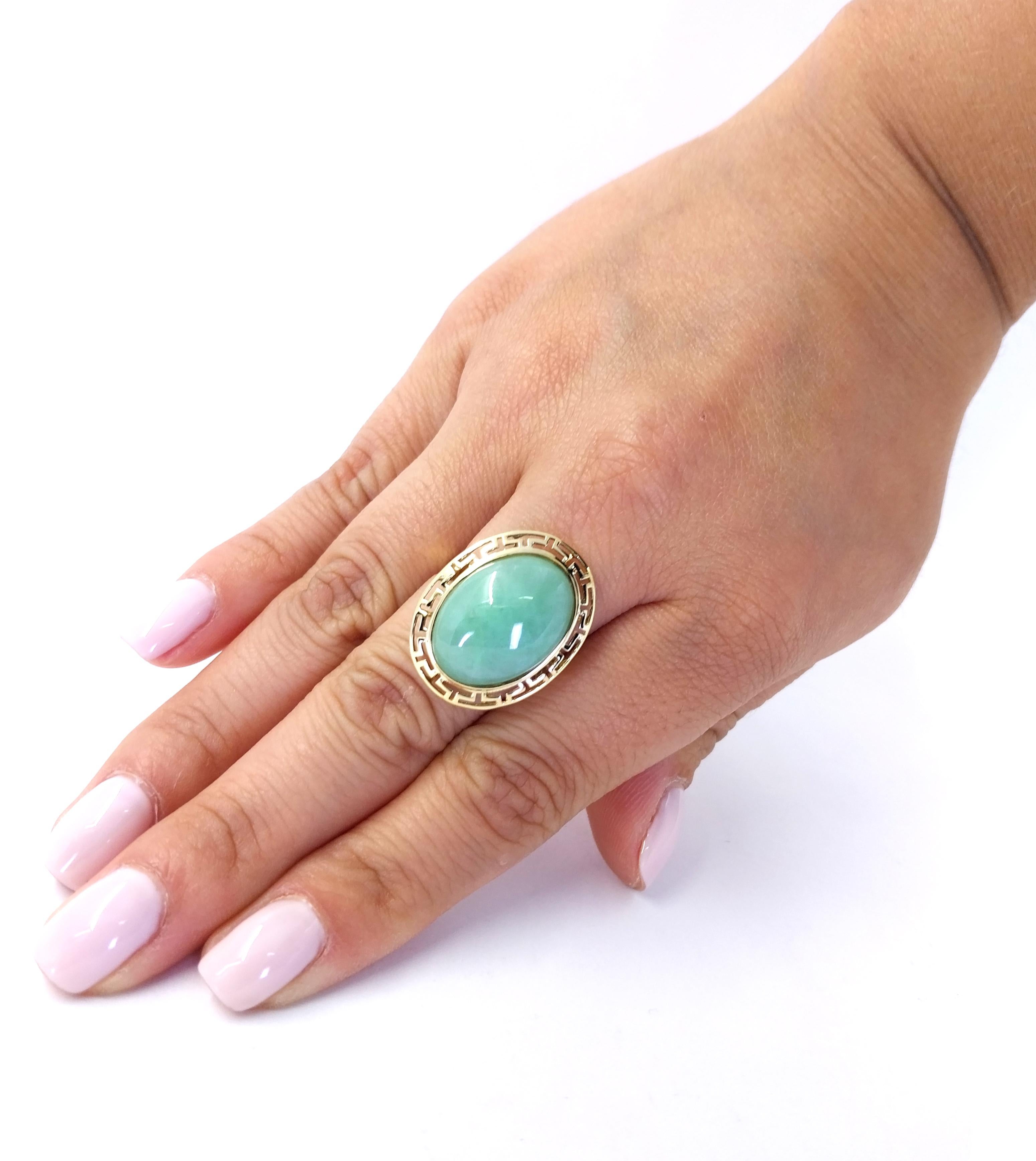 14 Karat Yellow Gold Ring Featuring An 18mm x 13mm Oval Cabochon Jade Surrounded with a Cutout Gold Border. Finger Size 7.5. Finished Weight is 4.2 Grams.

Matching earrings available separately.