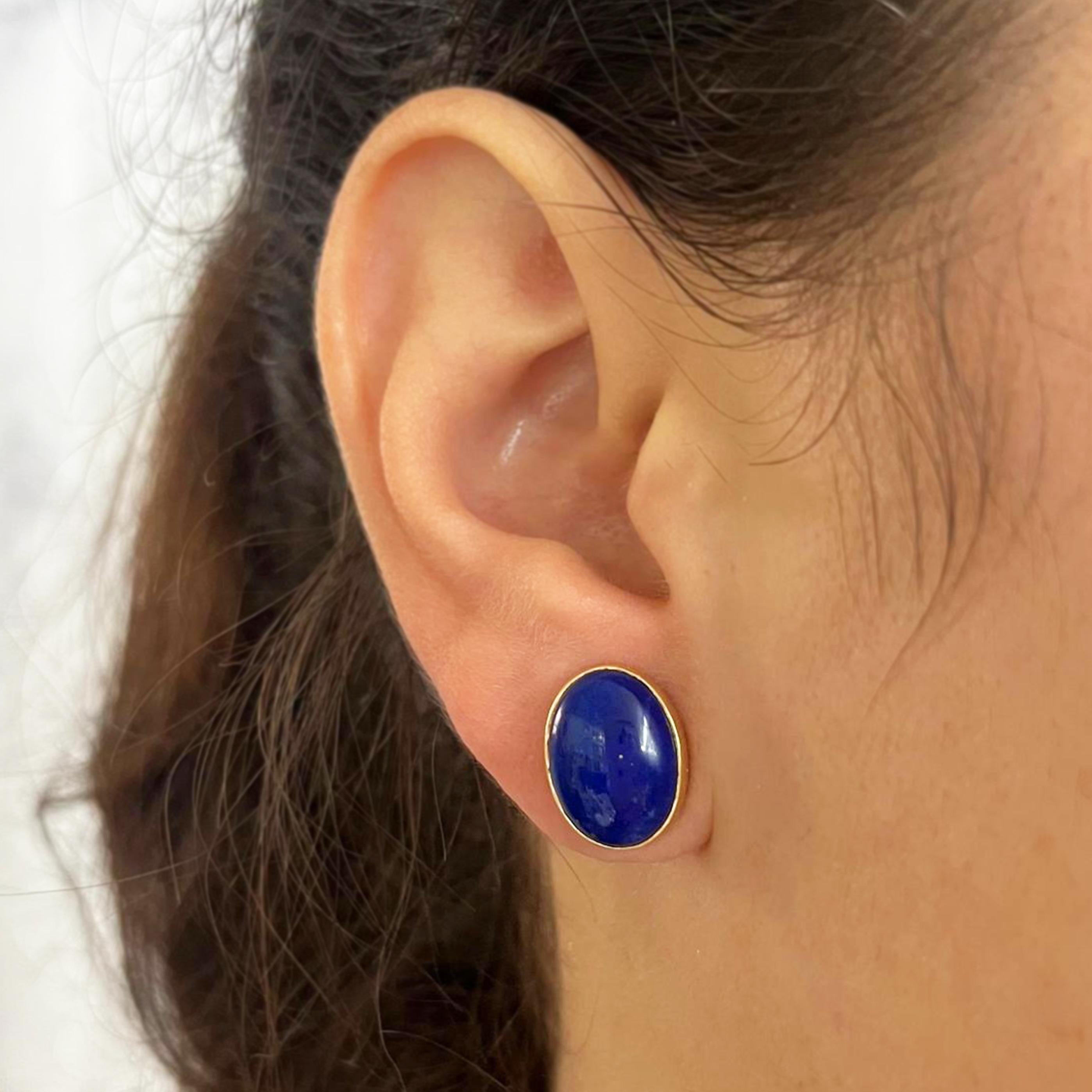 18 karat yellow gold oval stud earrings featuring 2 cabochon lapis lazuli set in a bezel. Pierced post with friction back. Finished weight is 6.0 grams.