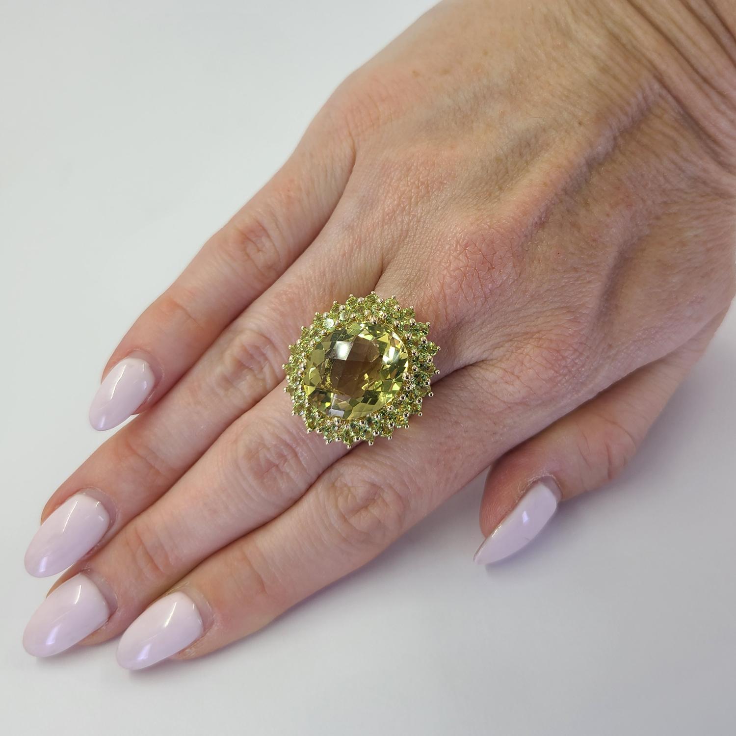 14 Karat Yellow Gold Cocktail Ring Featuring An Oval Lemon Quartz Approximately 10 Carats Accented By A Double Halo of 44 Round Green Tourmaline Totaling Approximately 1.30 Carats. Current Finger Size 7; Purchase Includes One Sizing Service Prior to